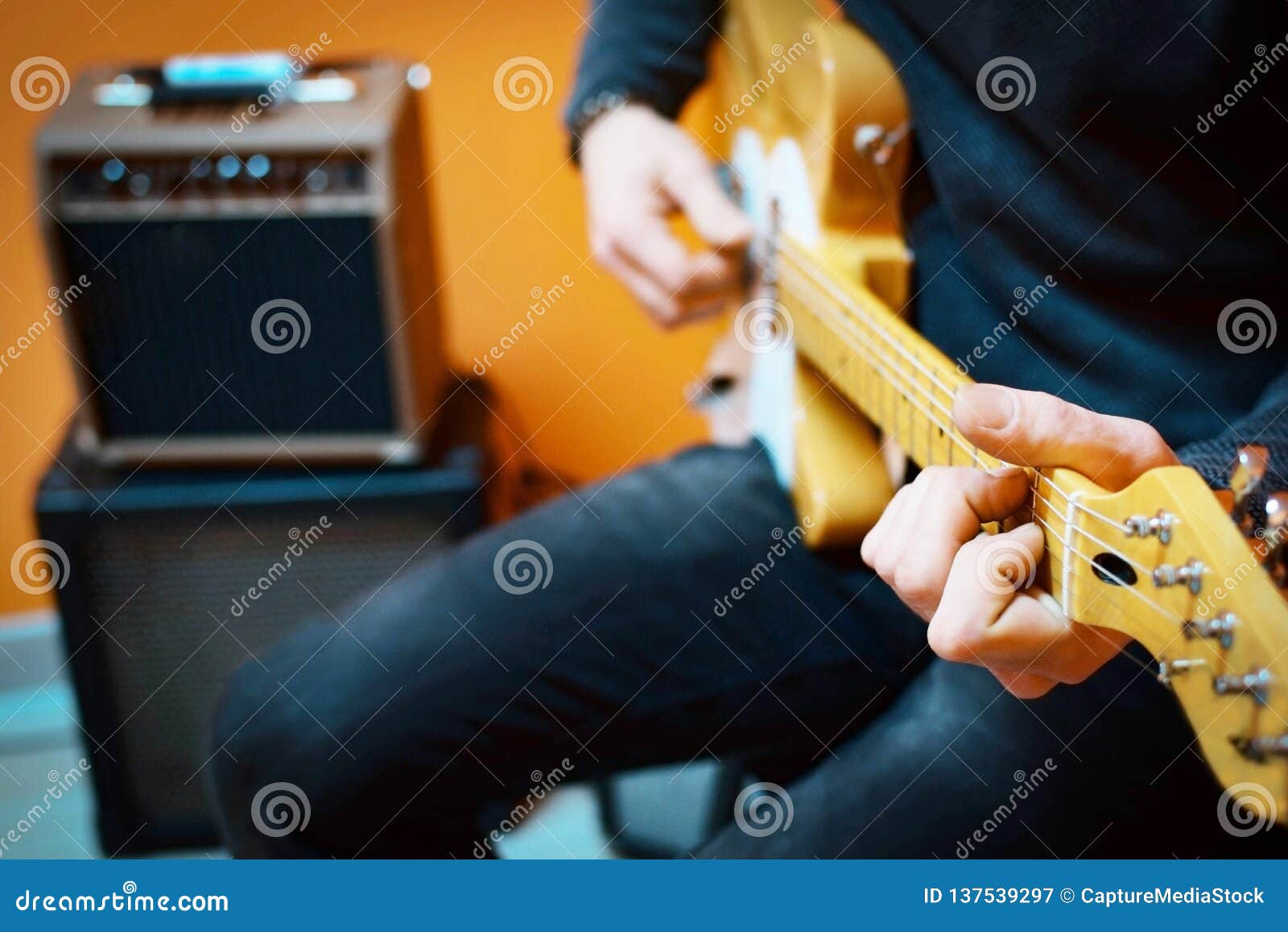 Man Practicing Electric Guitar Playing with Amplifiers. Guitar Lesson