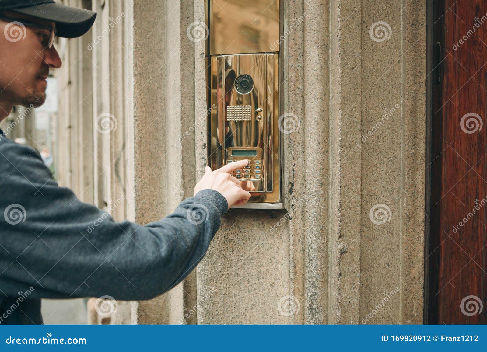 man presses a doorphone button
