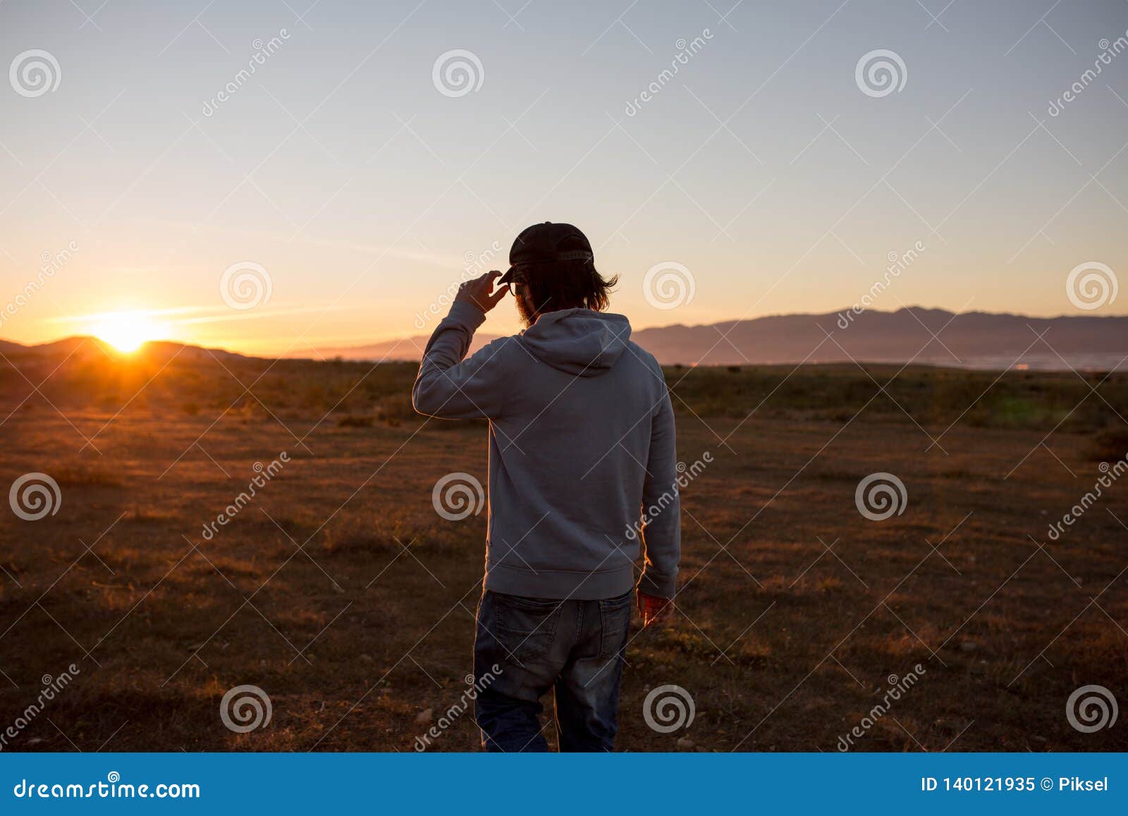 man in a pristine landscape during a beautiful blazing sunset