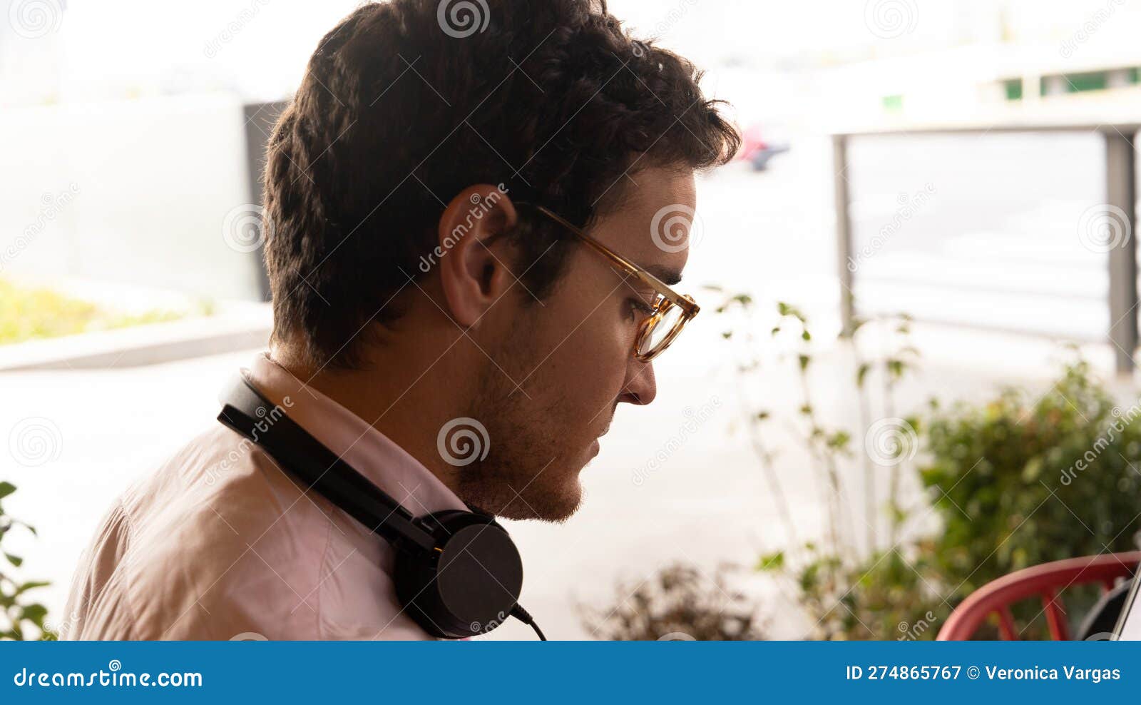 Man in Profile with His Headphones Resting on His Neck Stock Image