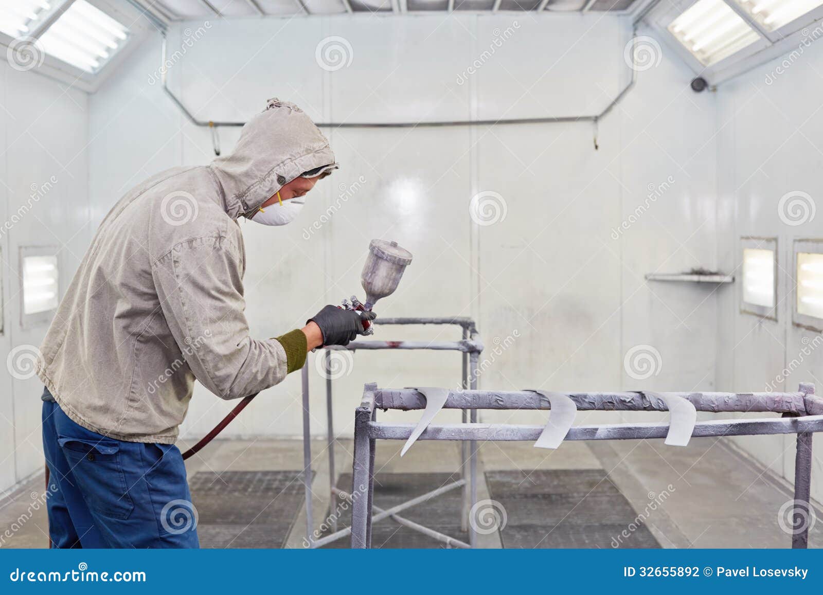 Man in Protective Clothes Works in Paintspraying Booth Stock Photo