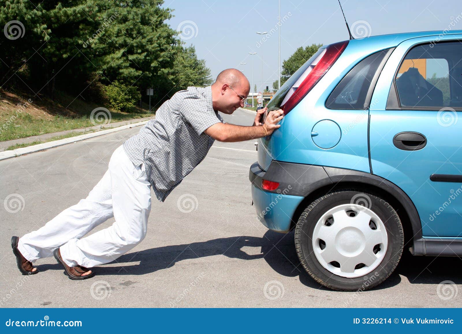 man pushing a car