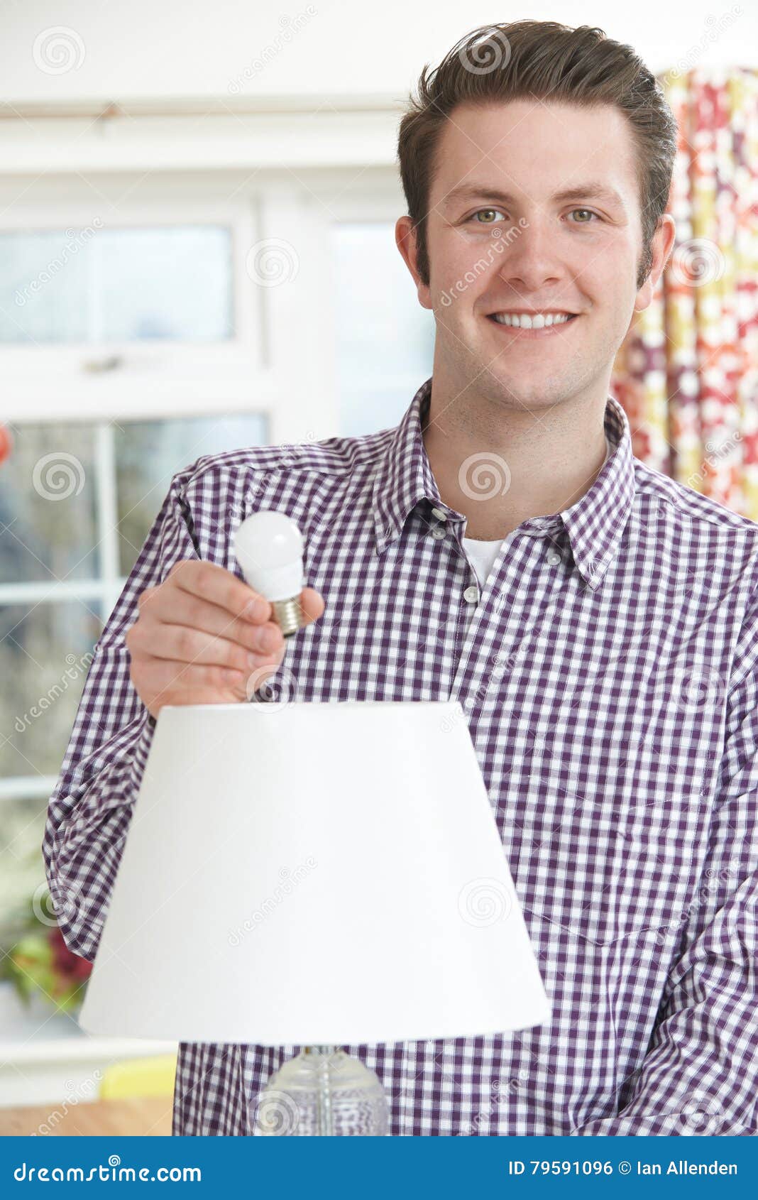 Man Putting Low Energy LED Lightbulb into Lamp at Home Stock Photo