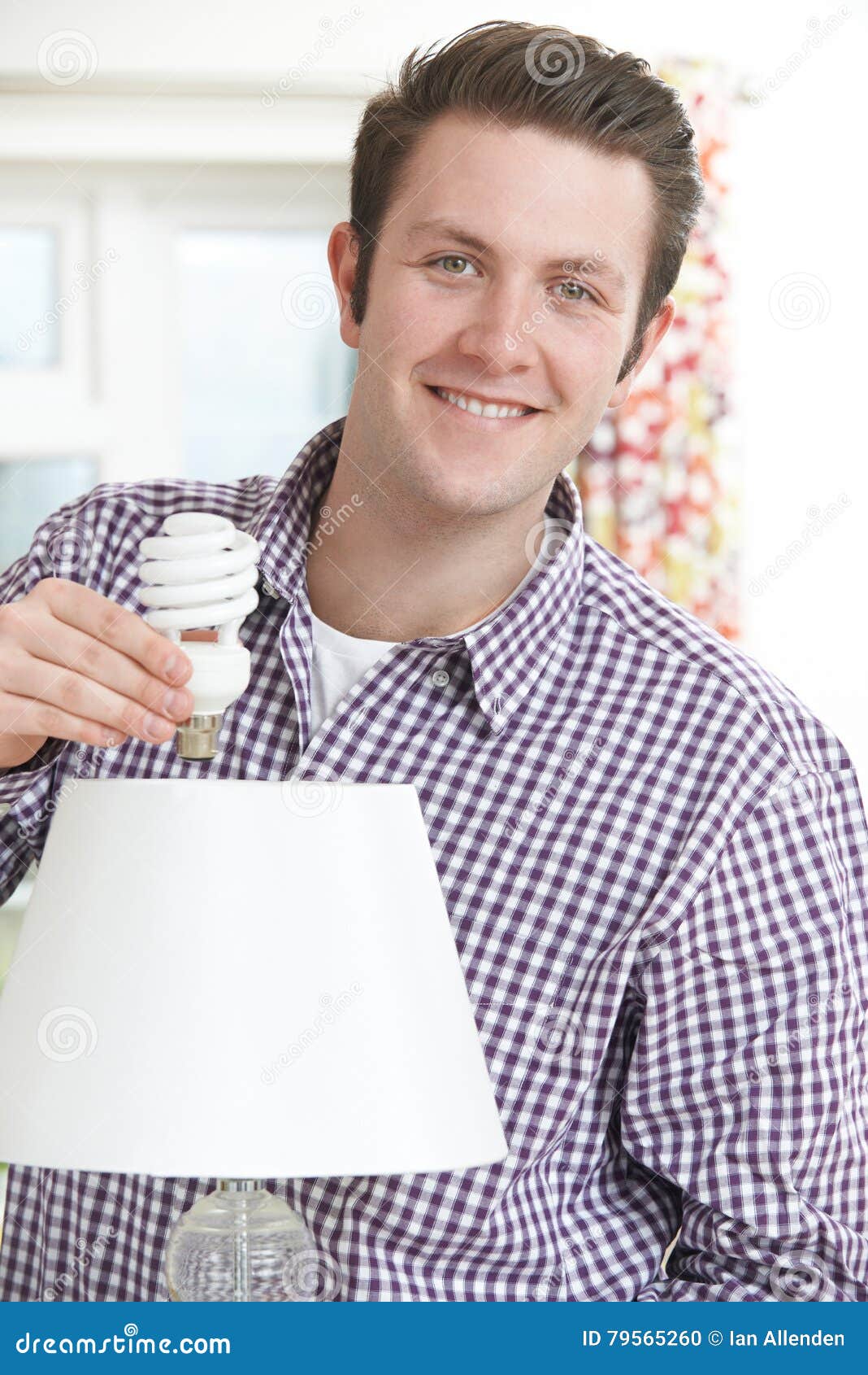 Man Putting Low Energy Lightbulb into Lamp at Home Stock Photo Image
