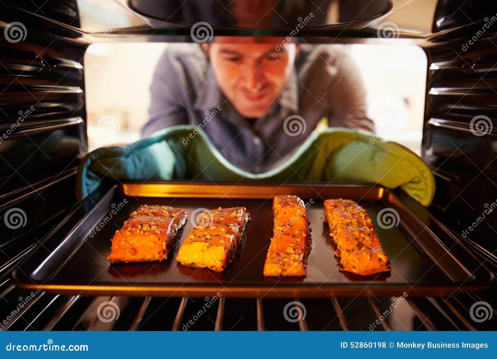 Man Putting Salmon Fillets into Oven To Cook Stock Photo Image of
