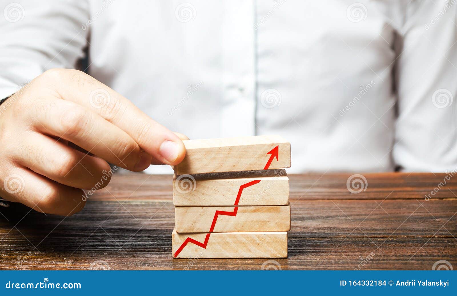 a man is putting together blocks with a red arrow chart. build a business and increase profits, achieve success. strategy