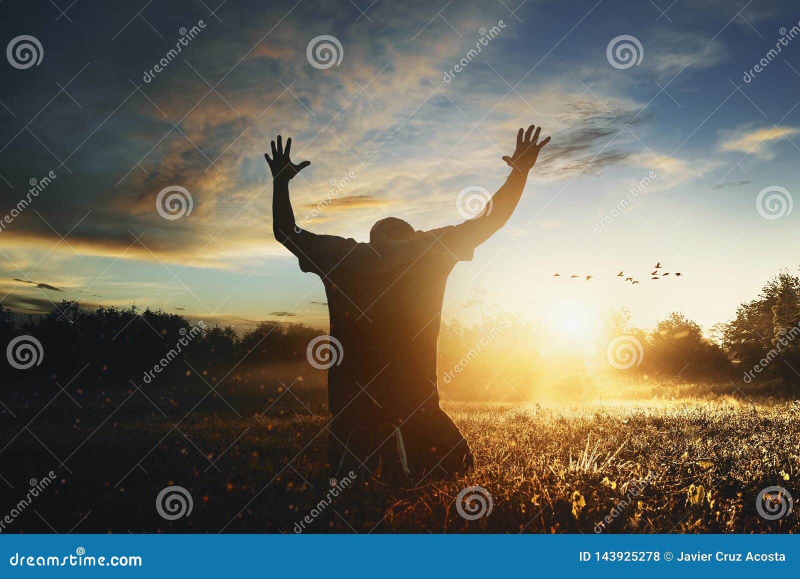 man raising his hands in worship