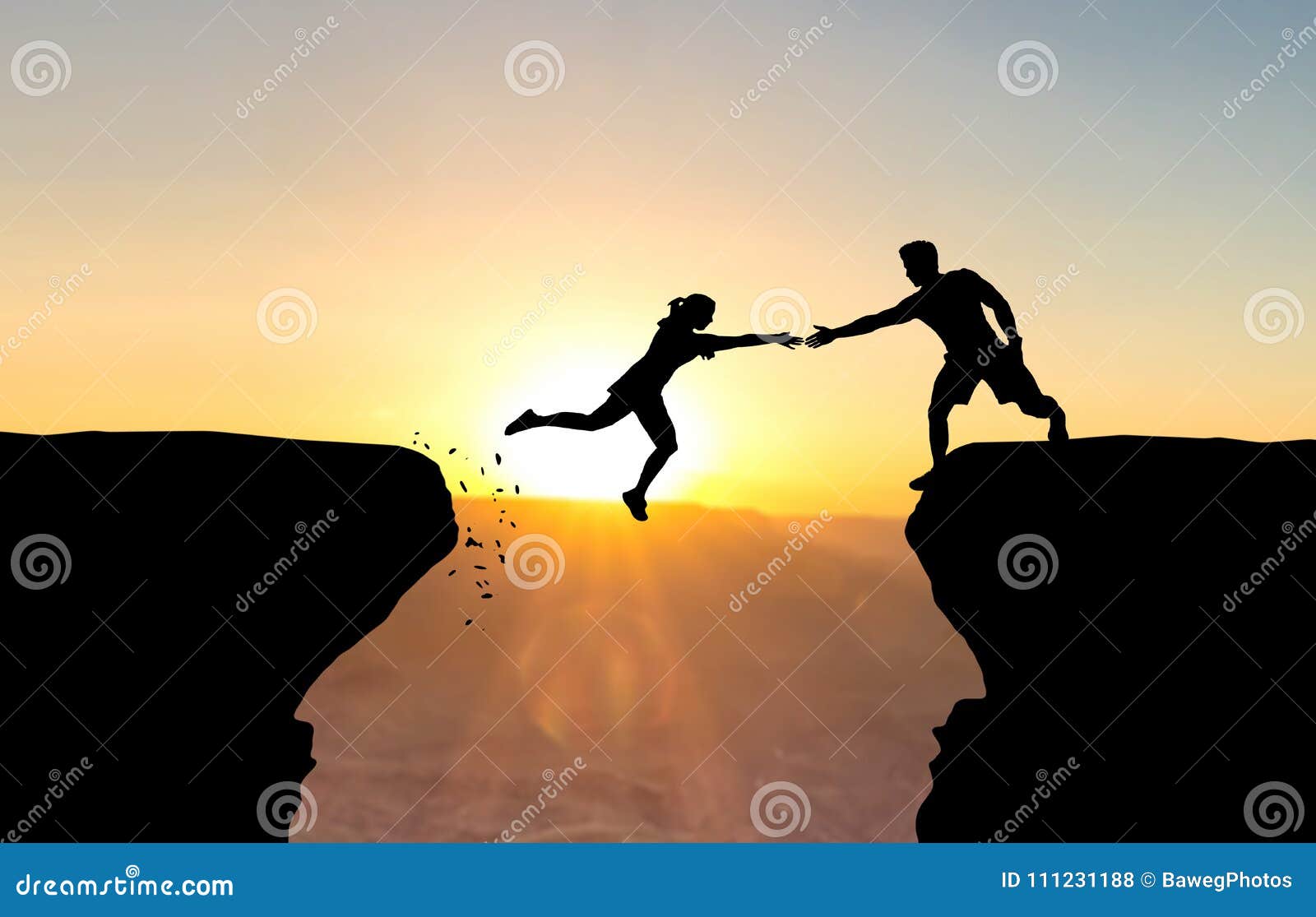 man reaching hand to woman jumping over abyss.