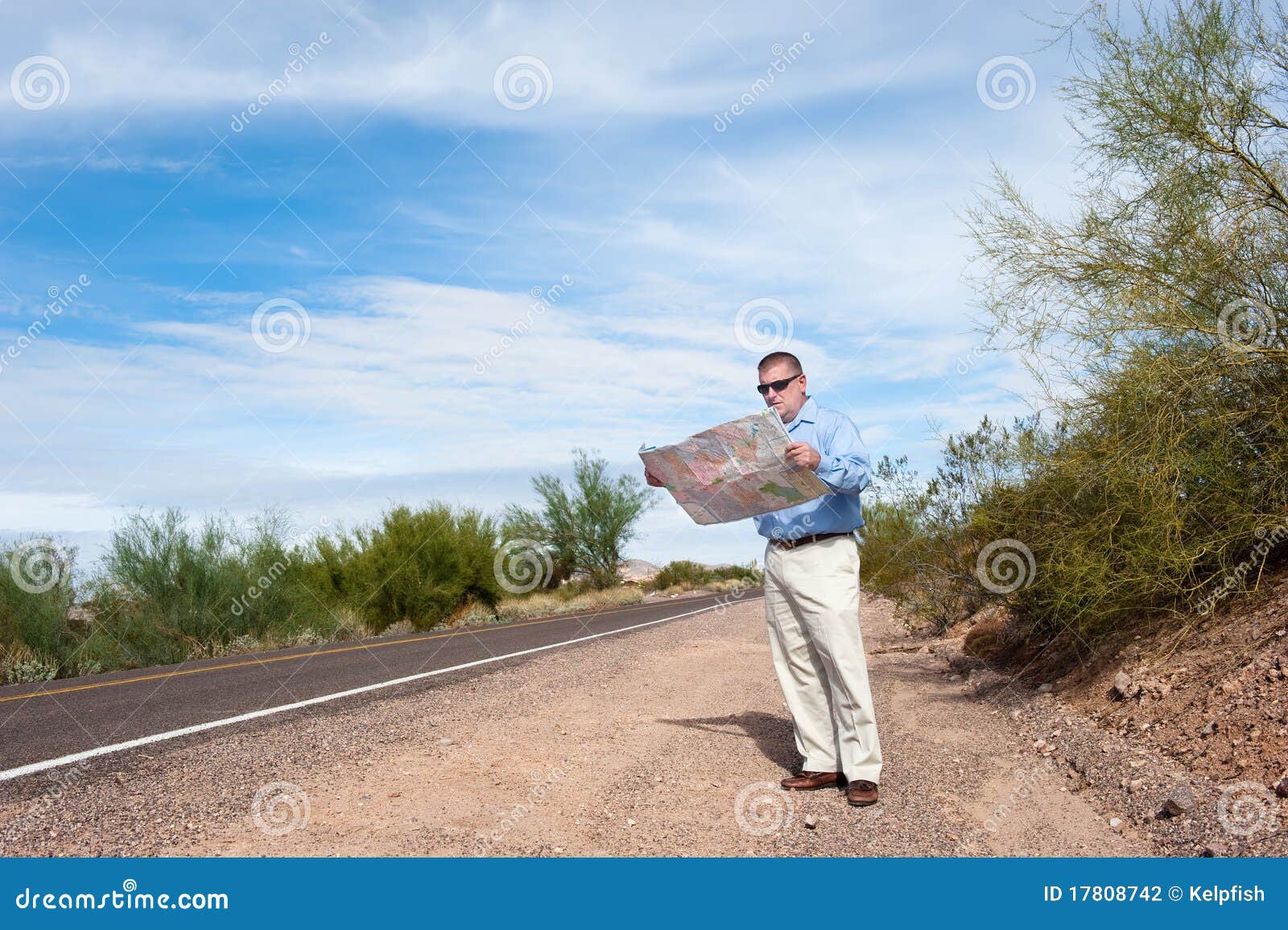 man reading map on deserted road