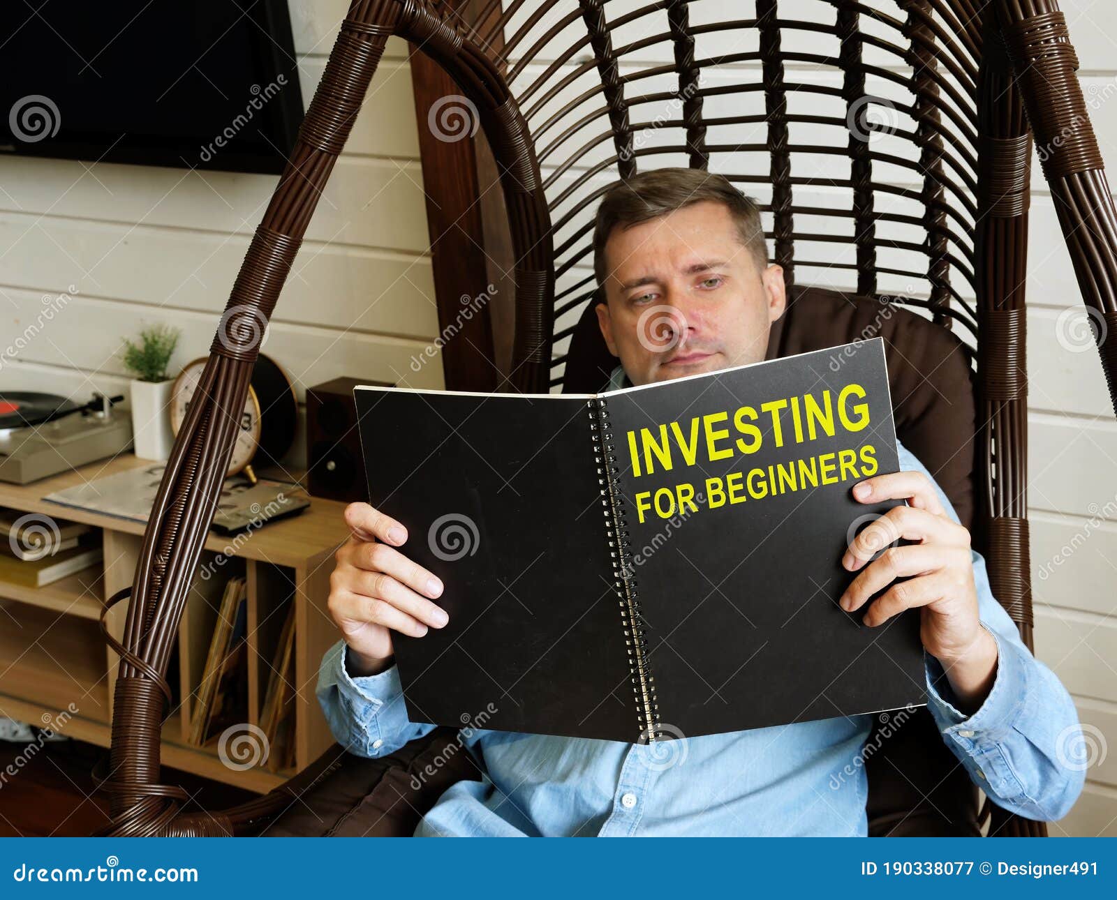 man reads investing for beginners at home.