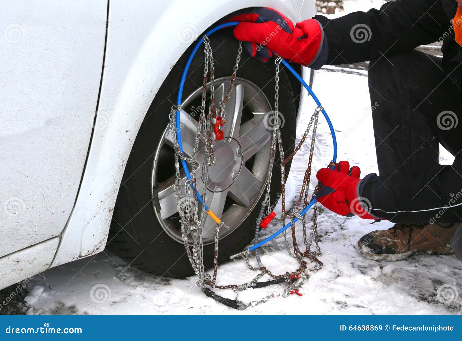 Man with Red Gloves Install Snow Chains in the Car Tyre Stock Image