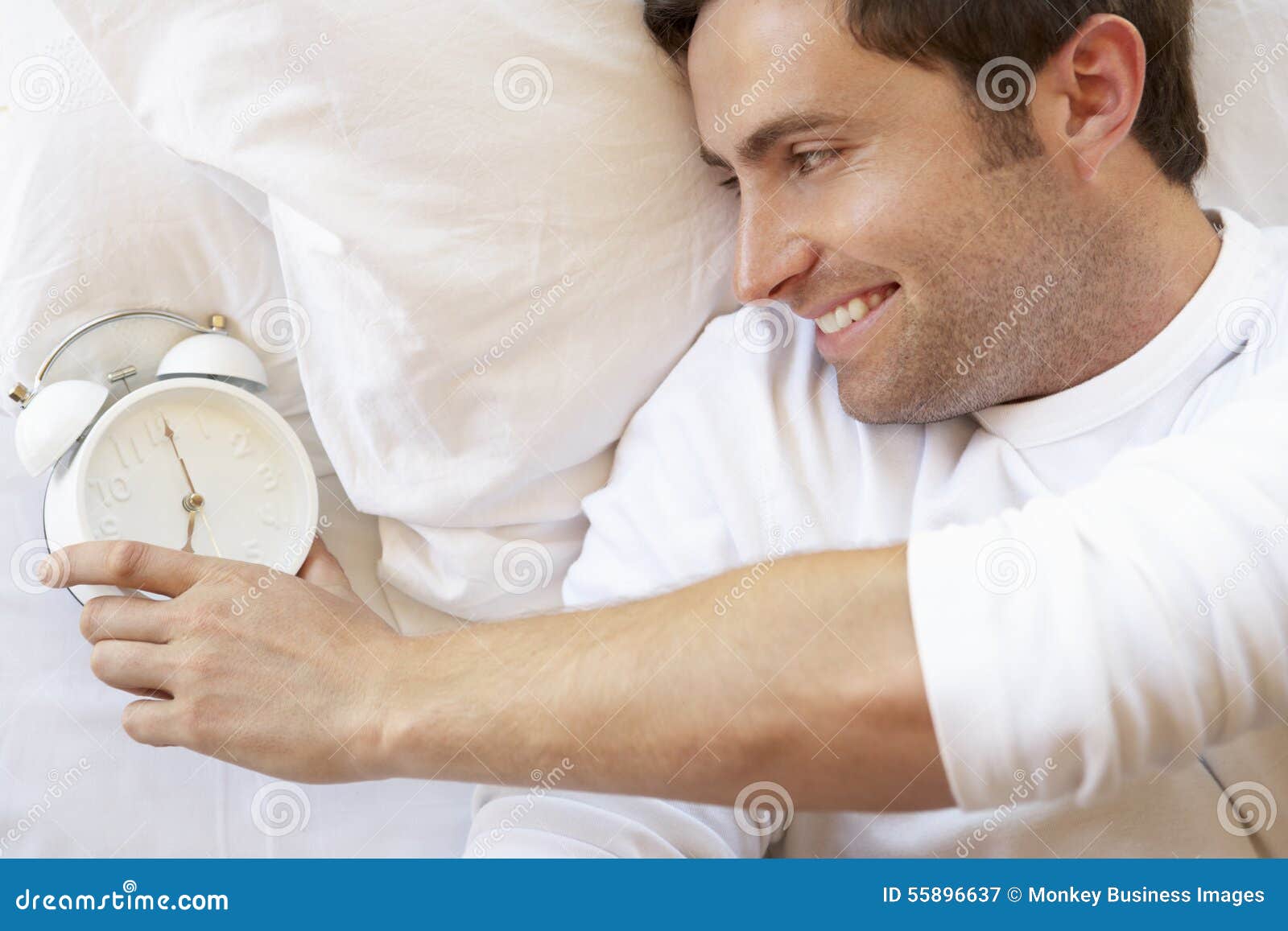 Man Relaxing in Bed with Alarm Clock Stock Image Image of serene