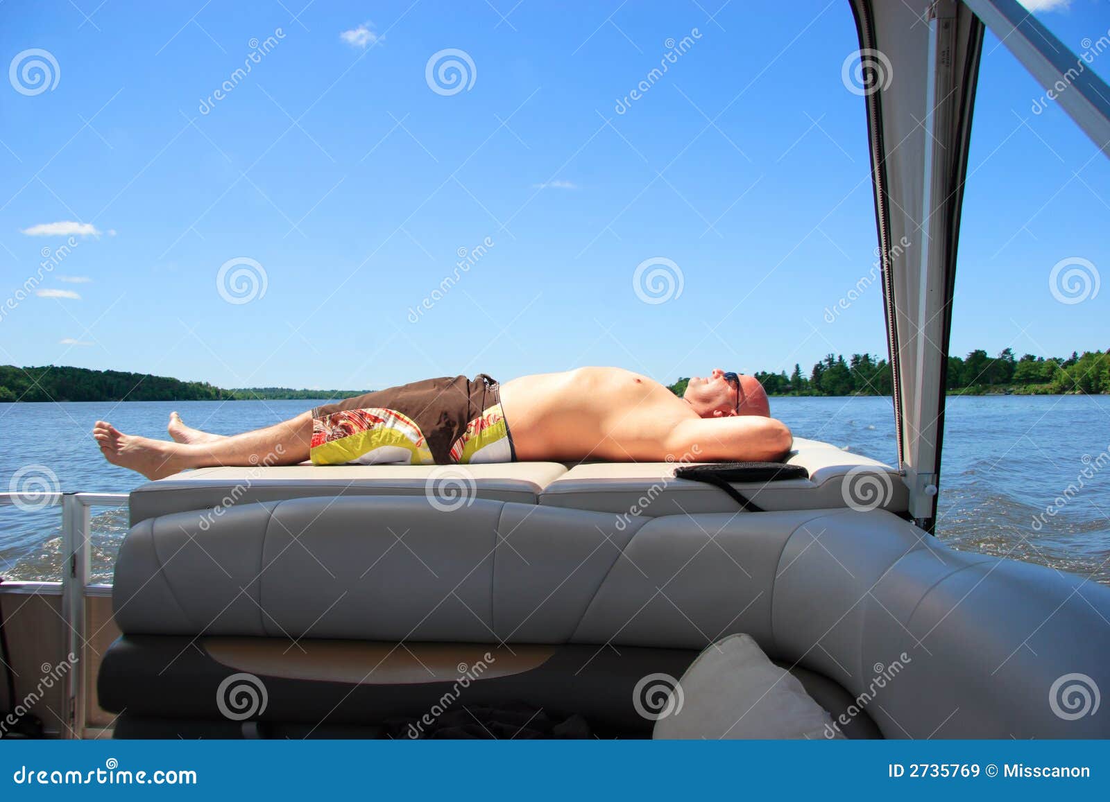 man relaxing on a boat on the Outaouais river in Quebec, Canada by a 