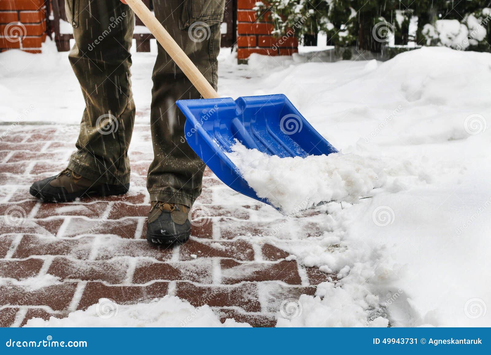 man removing snow from the sidewalk after snowstorm