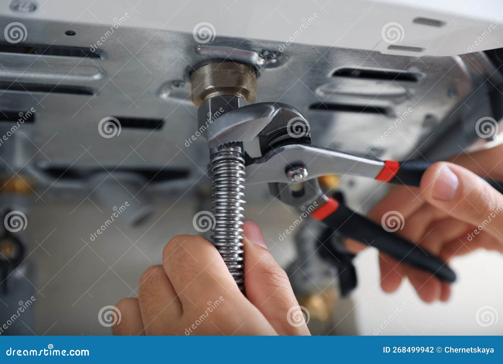man repairing gas boiler with waterpump plier, closeup