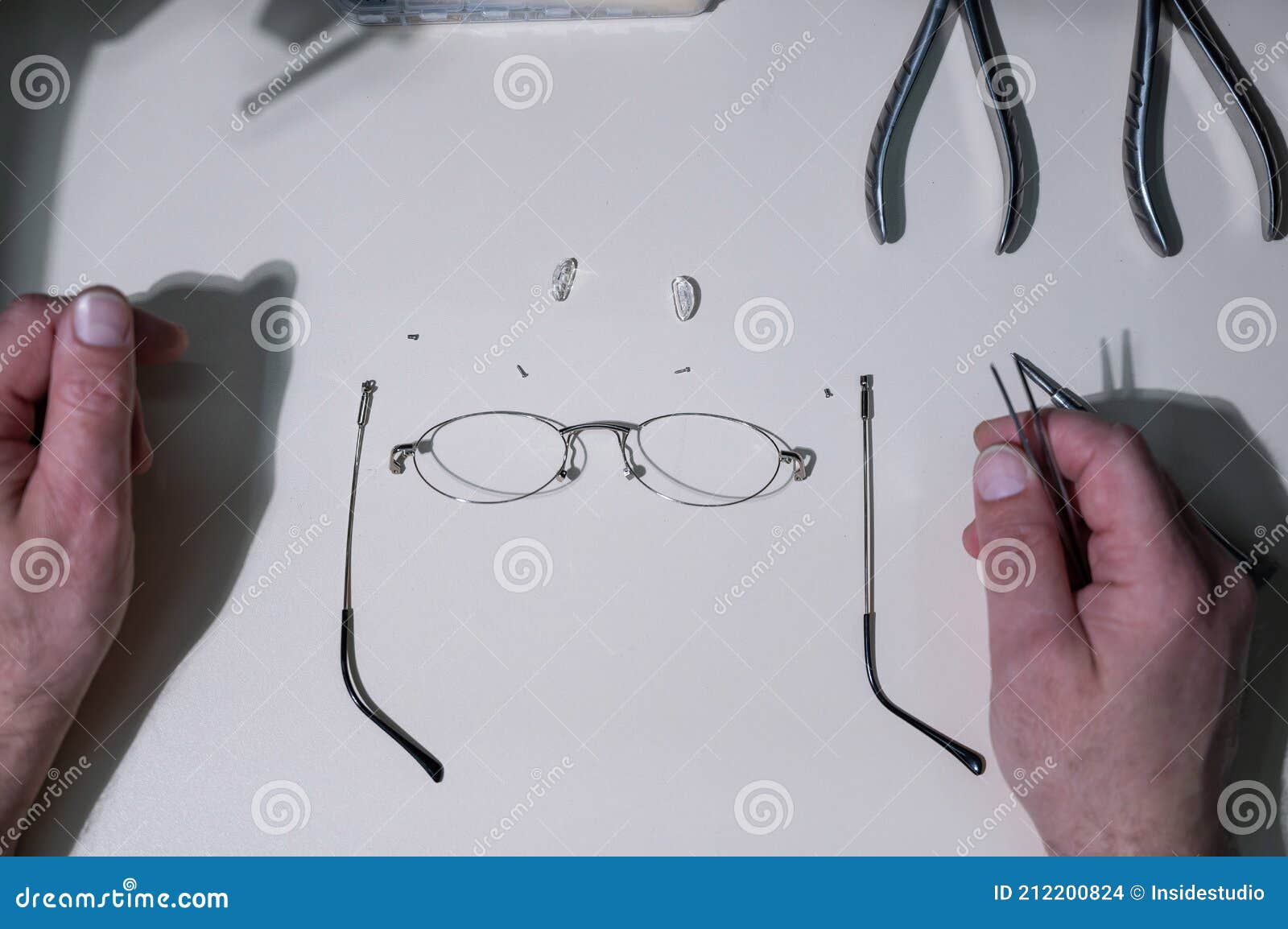 A Man Repairs a Broken Eyeglass Frame. Closeup of the Ophthalmologist