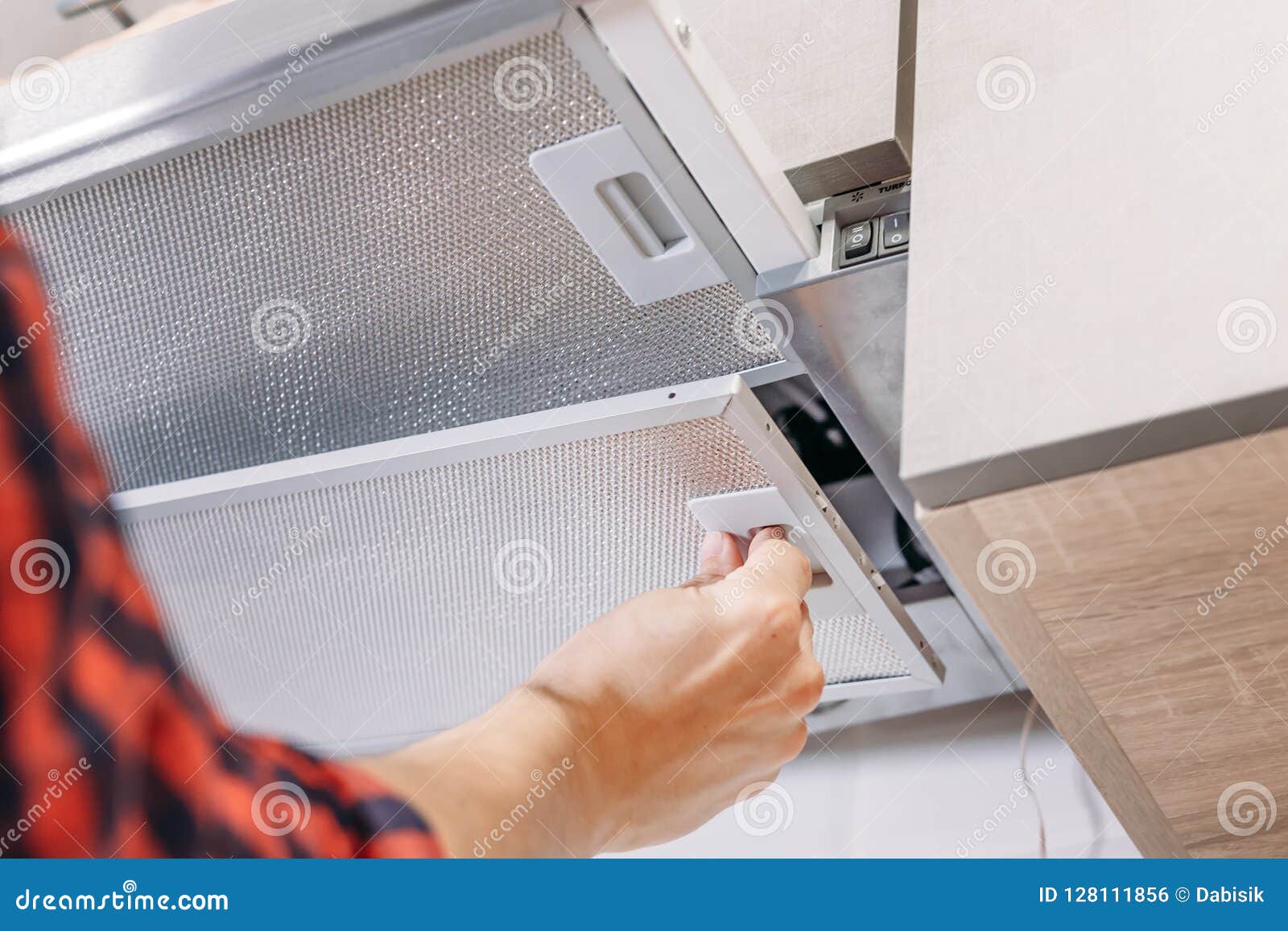 Man Repairs Hood in Kitchen. Replacement Filter in Cooker Hood Stock