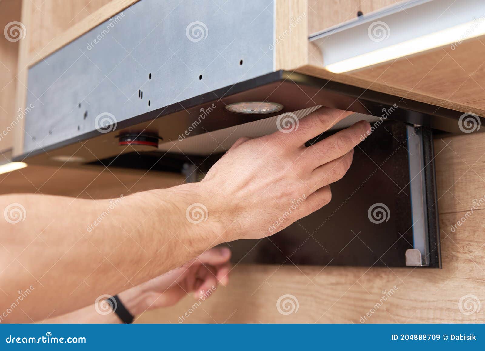 Man Repairs Hood in Kitchen. Replacement Filter in Cooker Hood Stock
