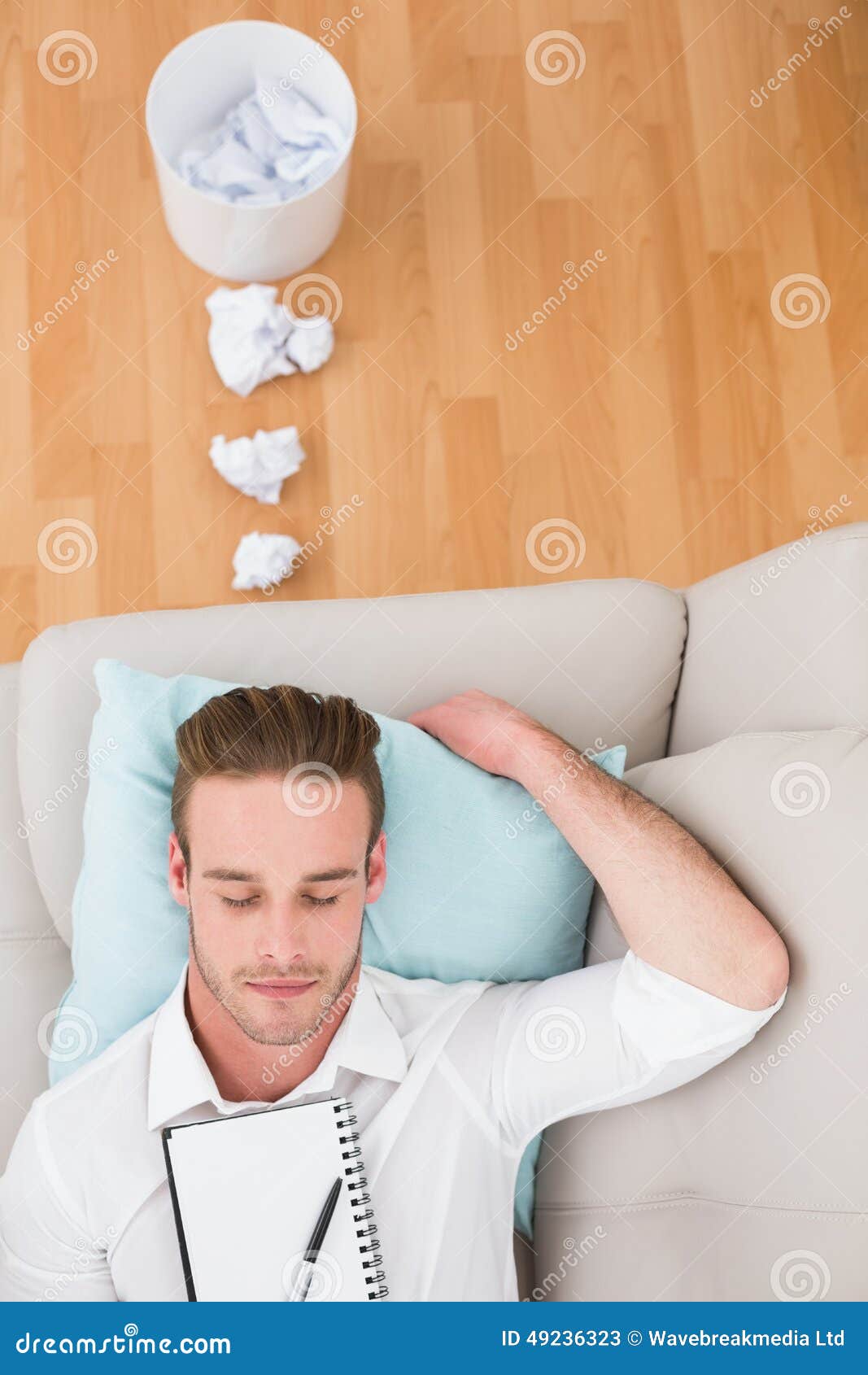 Man resting on couch with writer block at apartment