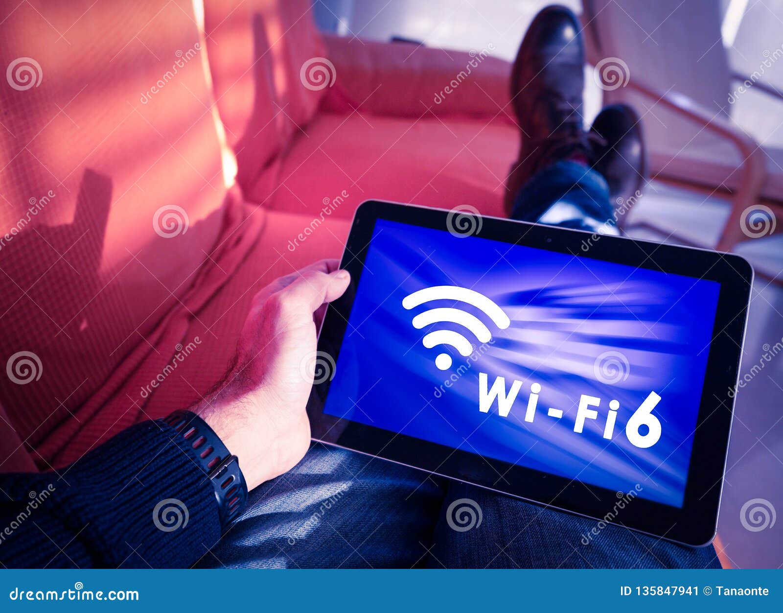 man resting with wifi 6 words and icon on tablet screen.