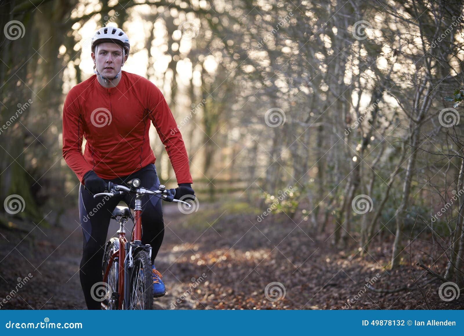 man riding mountain bike through woodlands