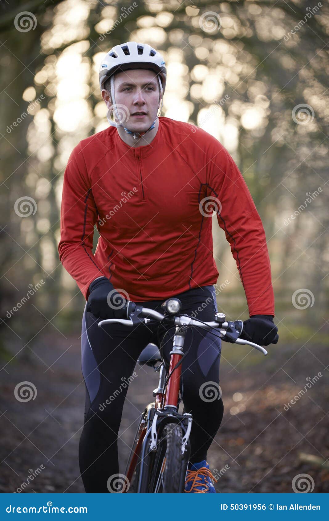 man riding mountain bike through woodlands