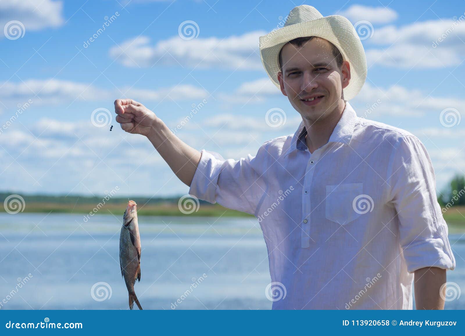 Man on the River in a Cowboy Hat Caught a Fish Stock Photo - Image