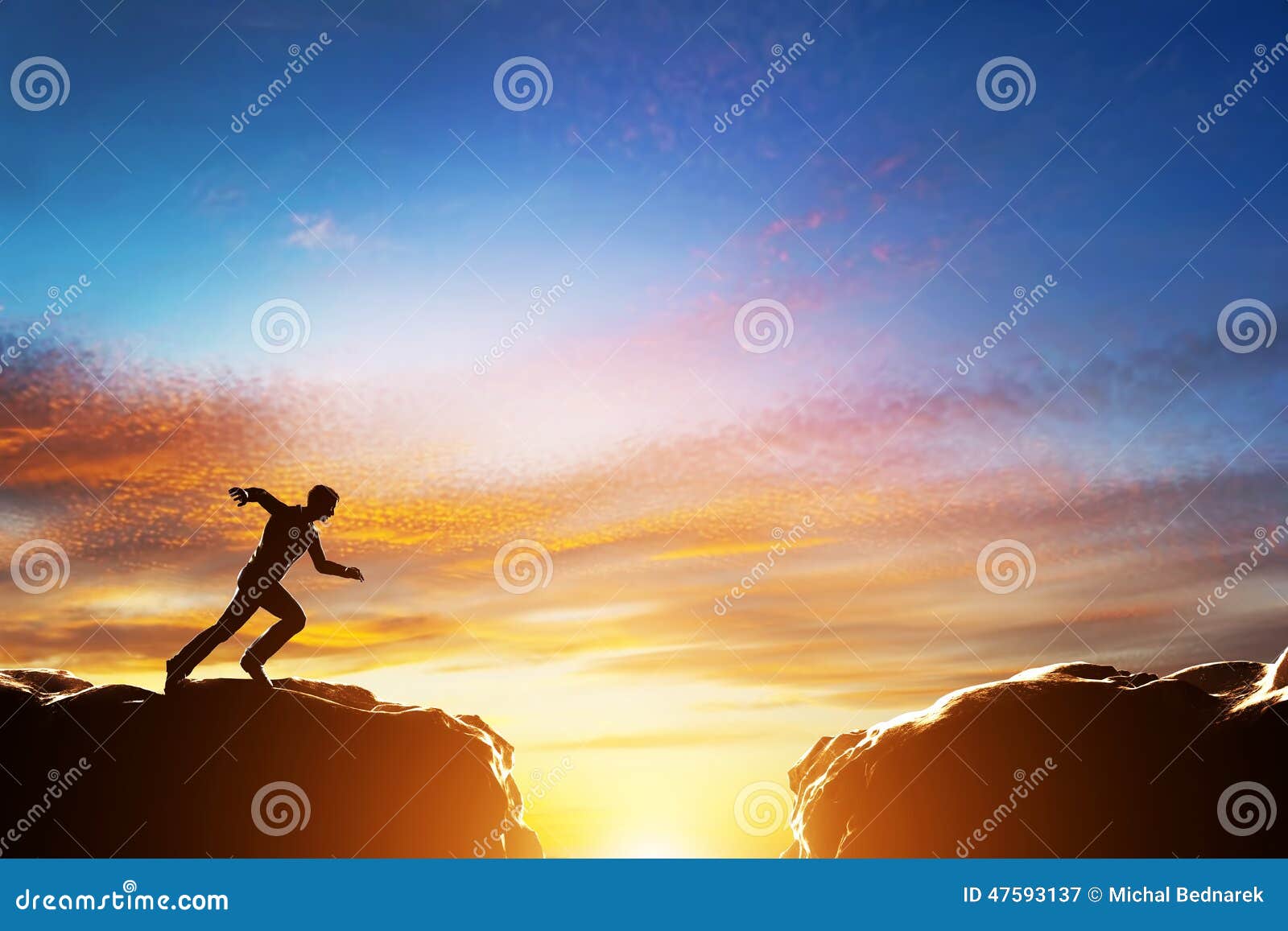 man running to jump over precipice between two mountains