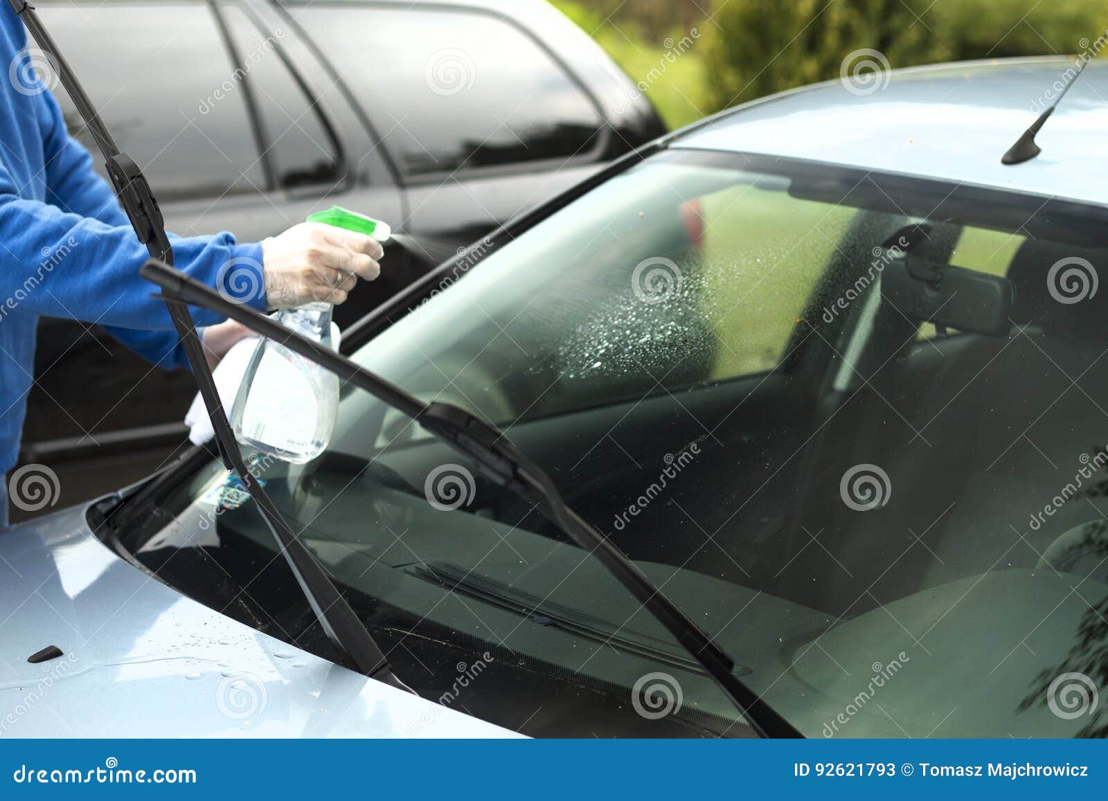 Man`s Hand Applies Liquid To Clean the Windshield of the Car Window