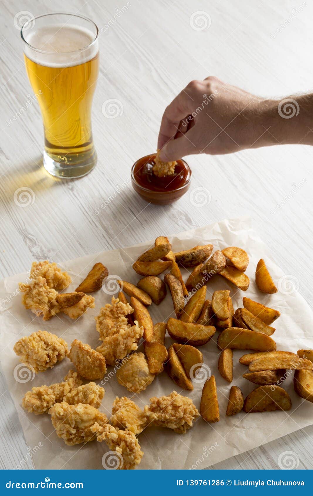 Man`s Hand Dipping Chicken Bites into Bbq Sauce, Side View Stock Photo