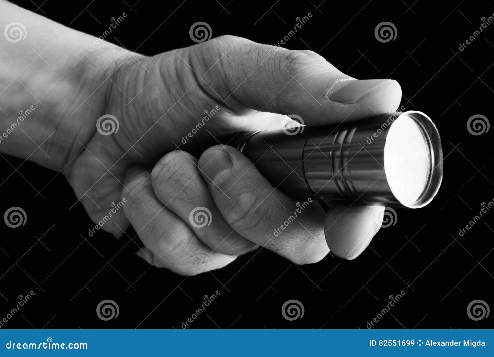 The Man`s Hand Holding a Flashlight on Black Background Stock Image
