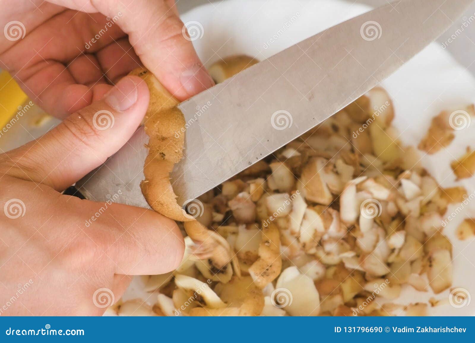 Man`s Hands is Peeling Potato with Kitchen Knife. Stock Photo Image