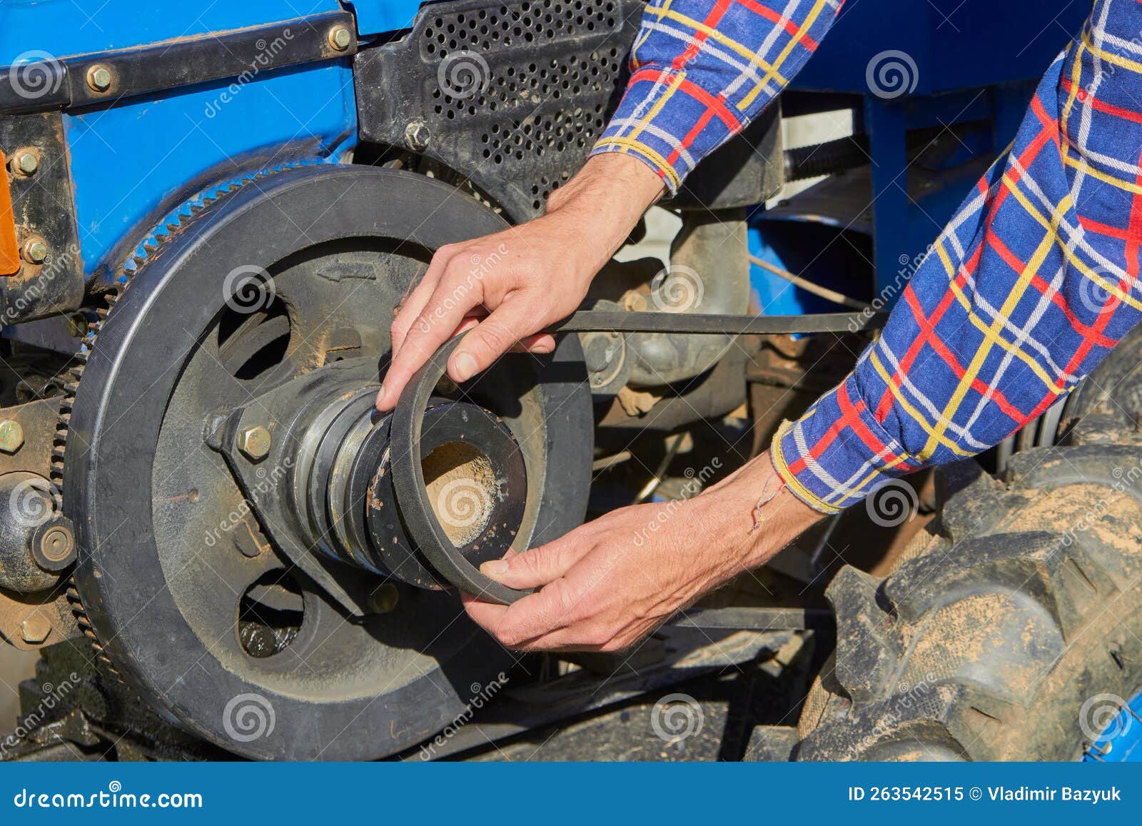 Belt Replacement on a Tractor,the Man`s Hands Put a Belt on the Motor