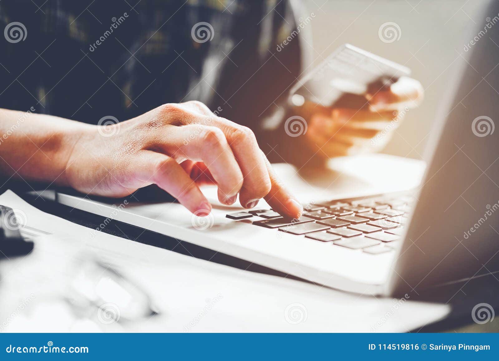 man`s hands typing laptop keyboard and holding credit card onlin