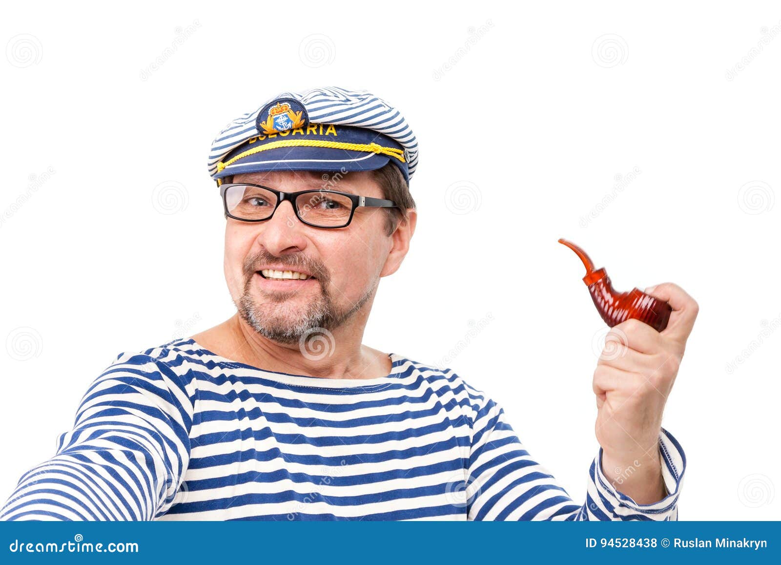 A Man Sailor in a Cap with a Smoking Pipe in Front of a White Ba Stock