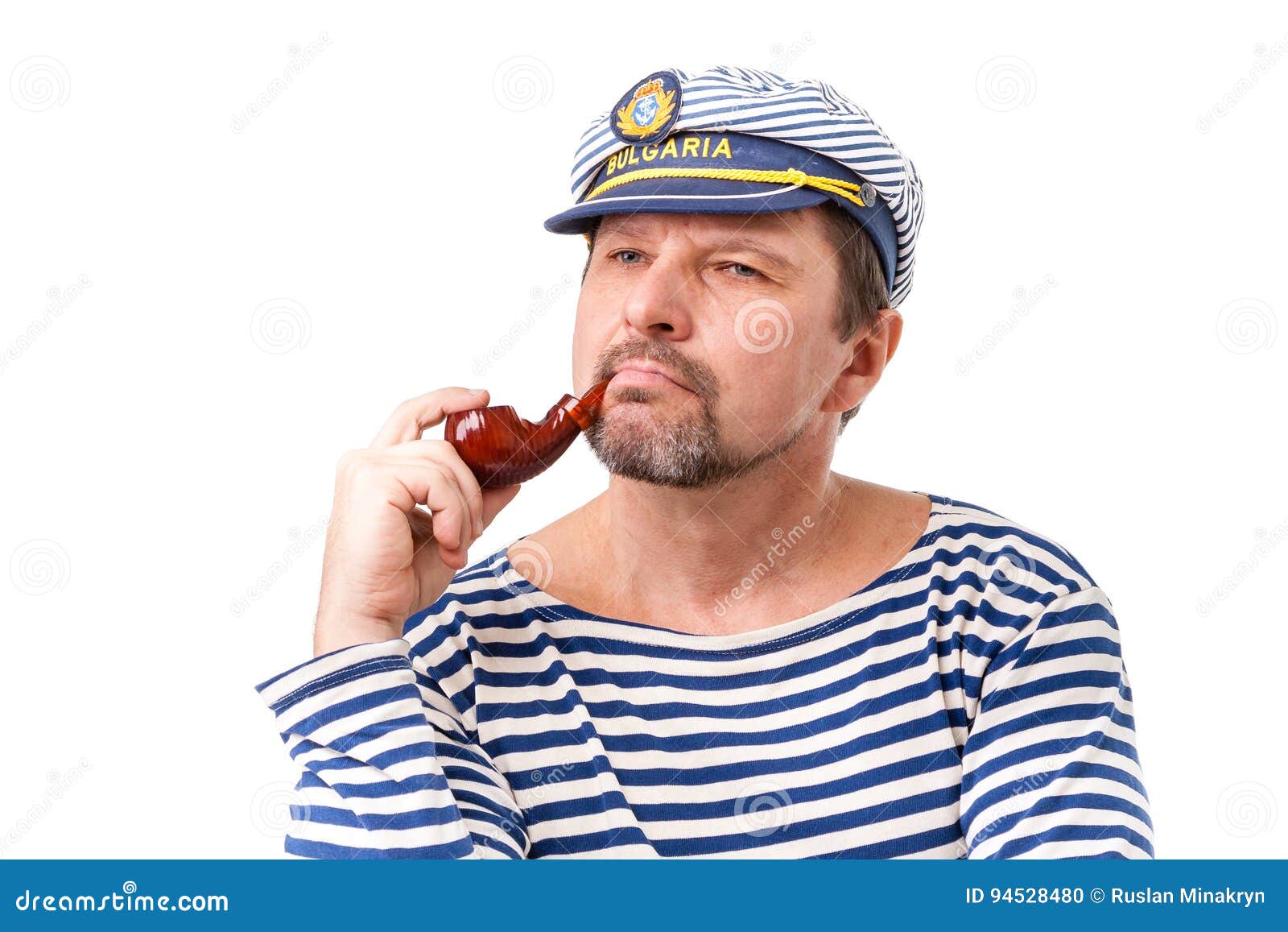 A Man Sailor in a Cap with a Smoking Pipe in Front of a White Ba Stock