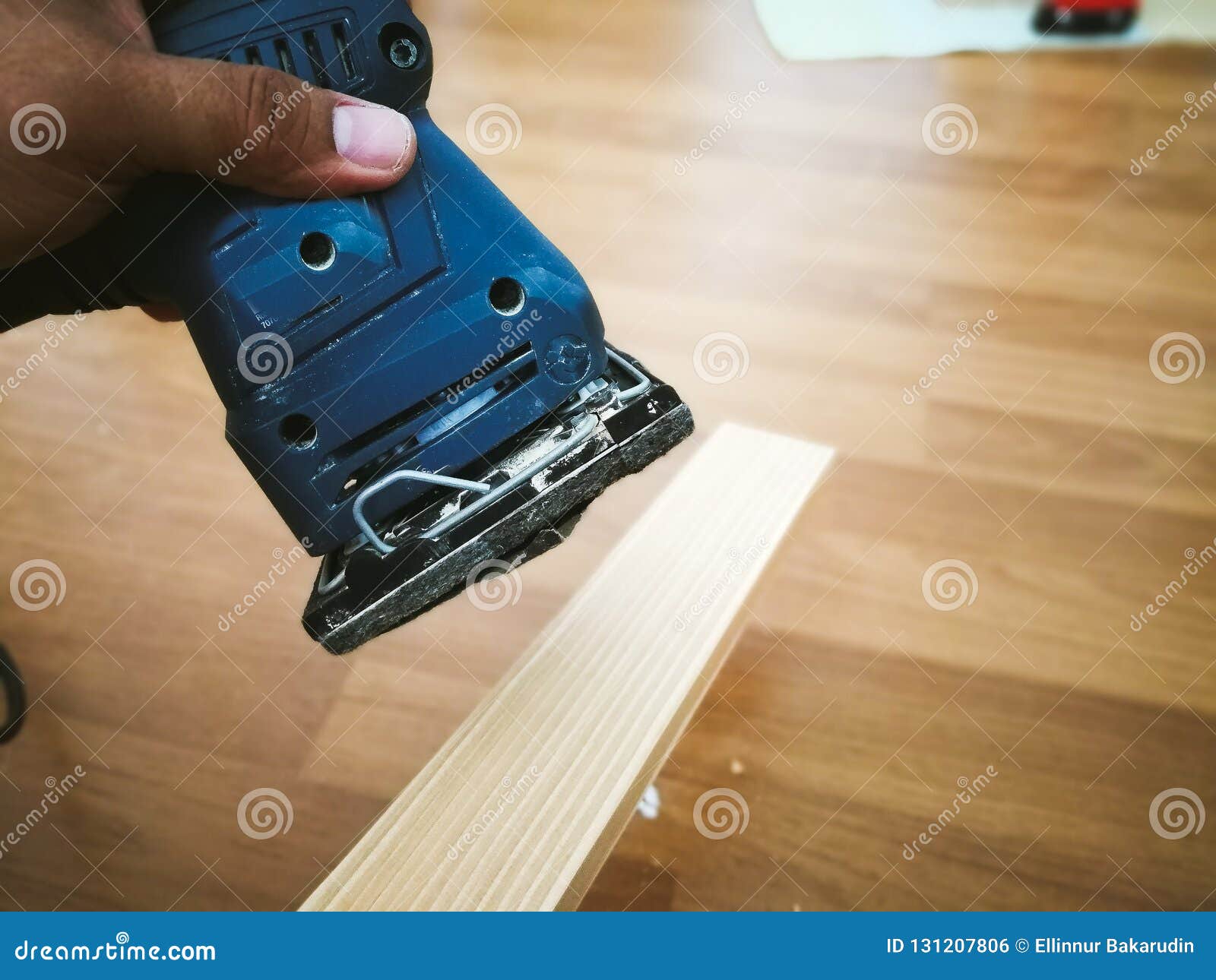Man Sanding Wood with Square Sander in a Stock Photo Image
