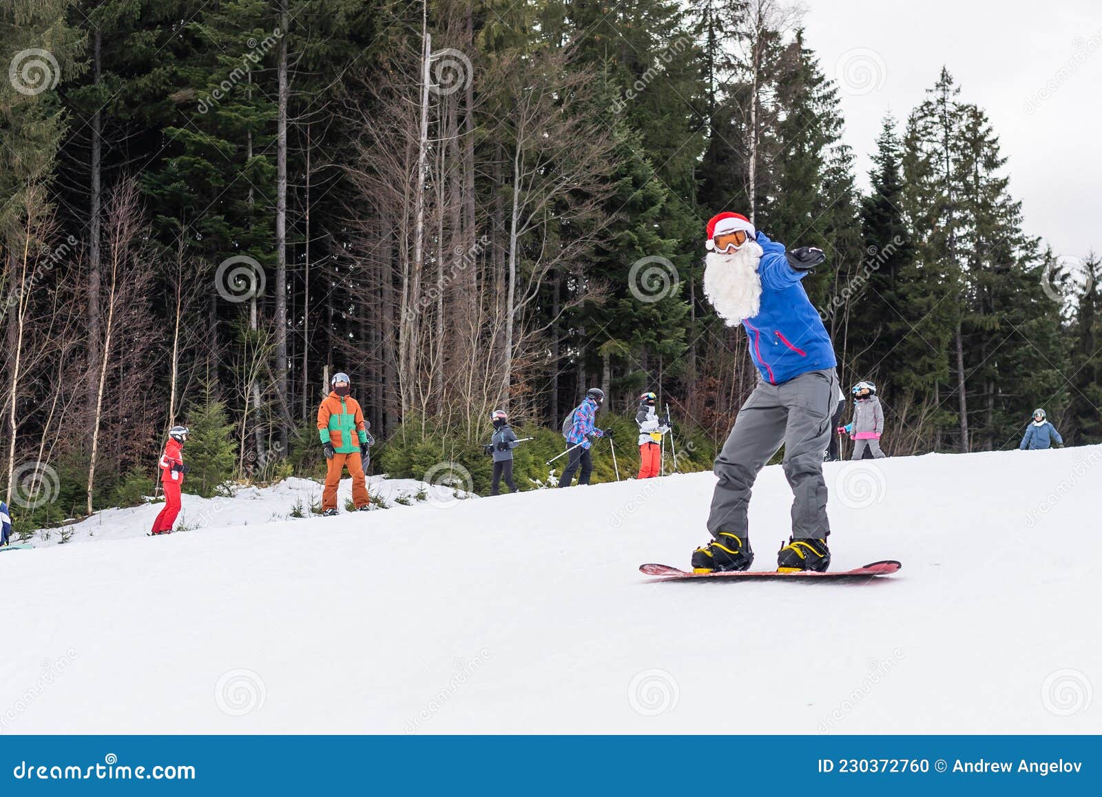 A Man in a Santa Hat with a Snowboard at a Ski Resort. Stock Photo