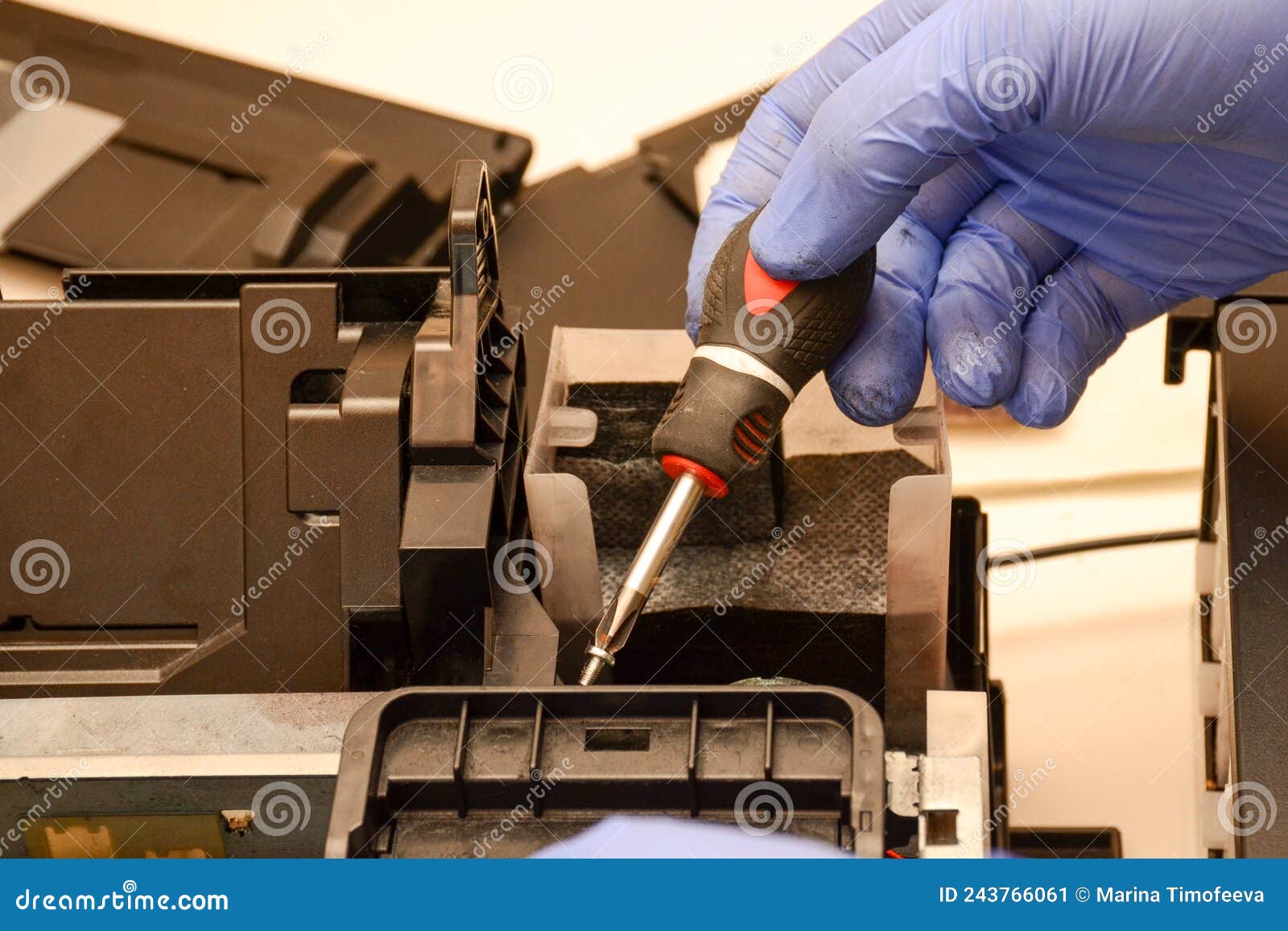 A Man with a Screwdriver Assembles a Printer. Repair of Office