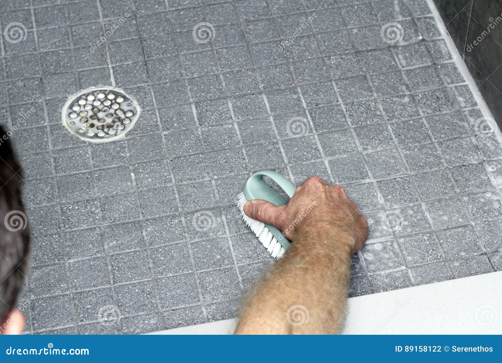 man scrubbing a shower floor