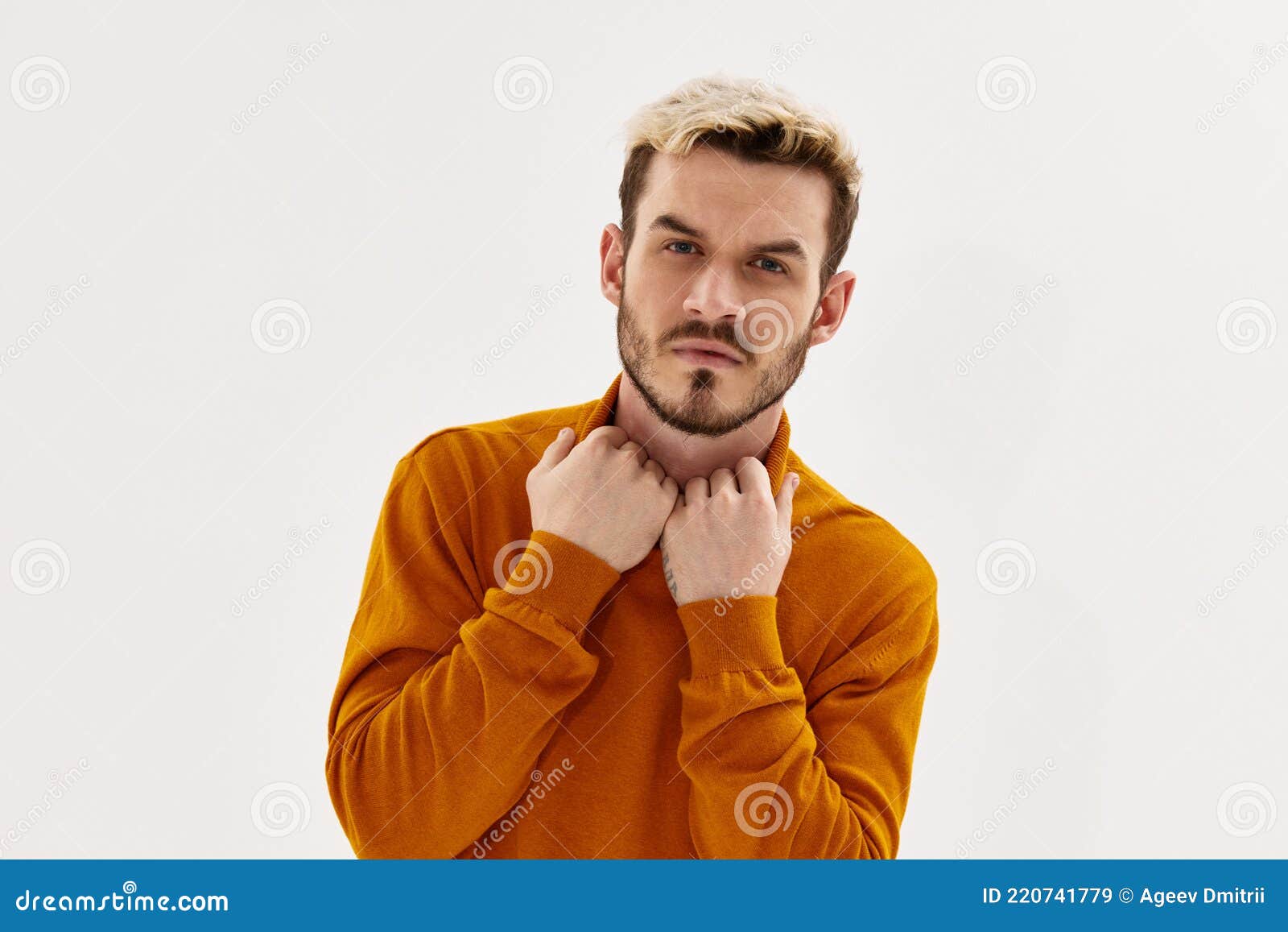 A Man with a Serious Expression Holding His Collar Looking Forward ...