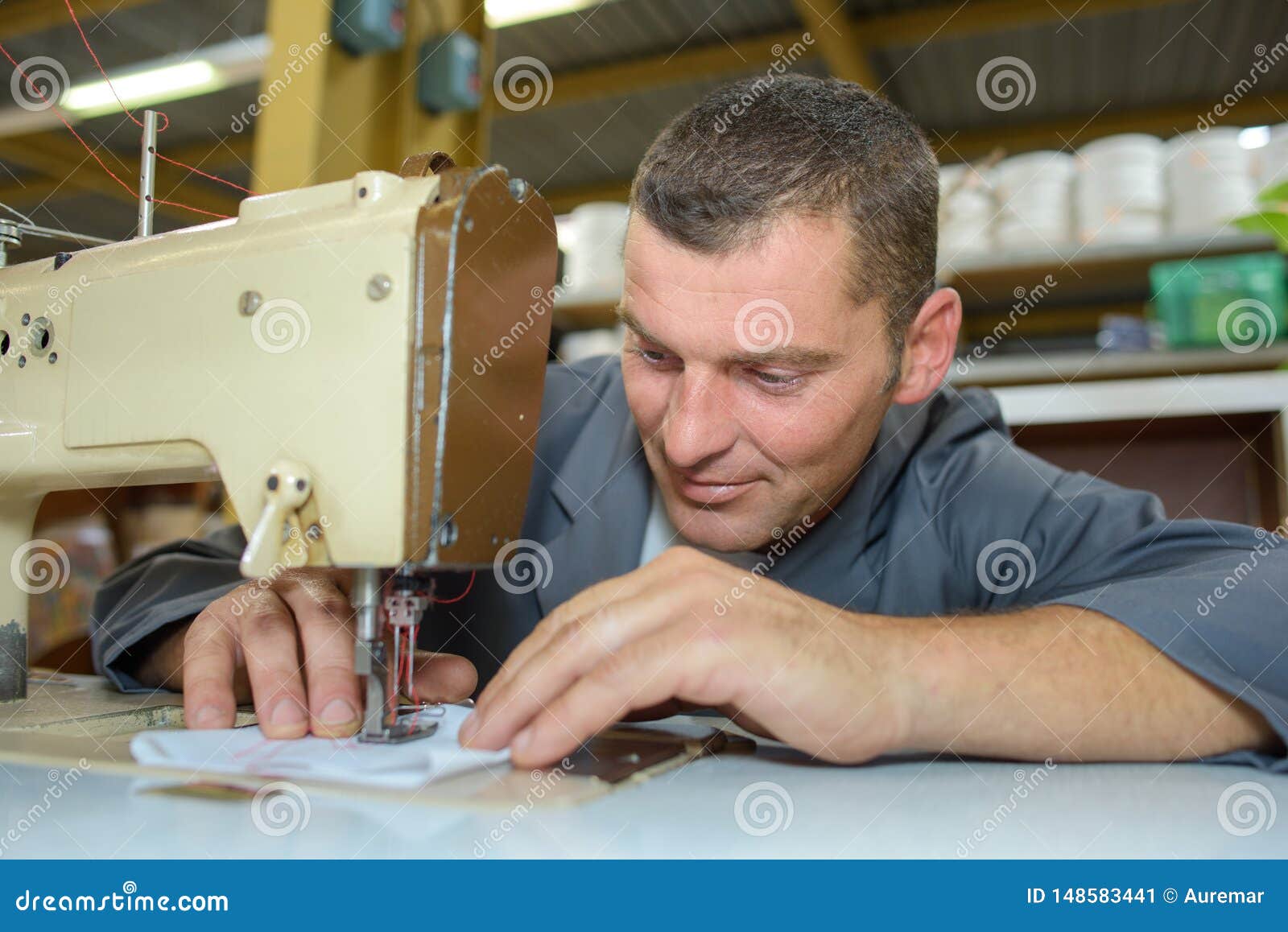 Man on sewing machine stock image. Image of warehouse - 148583441