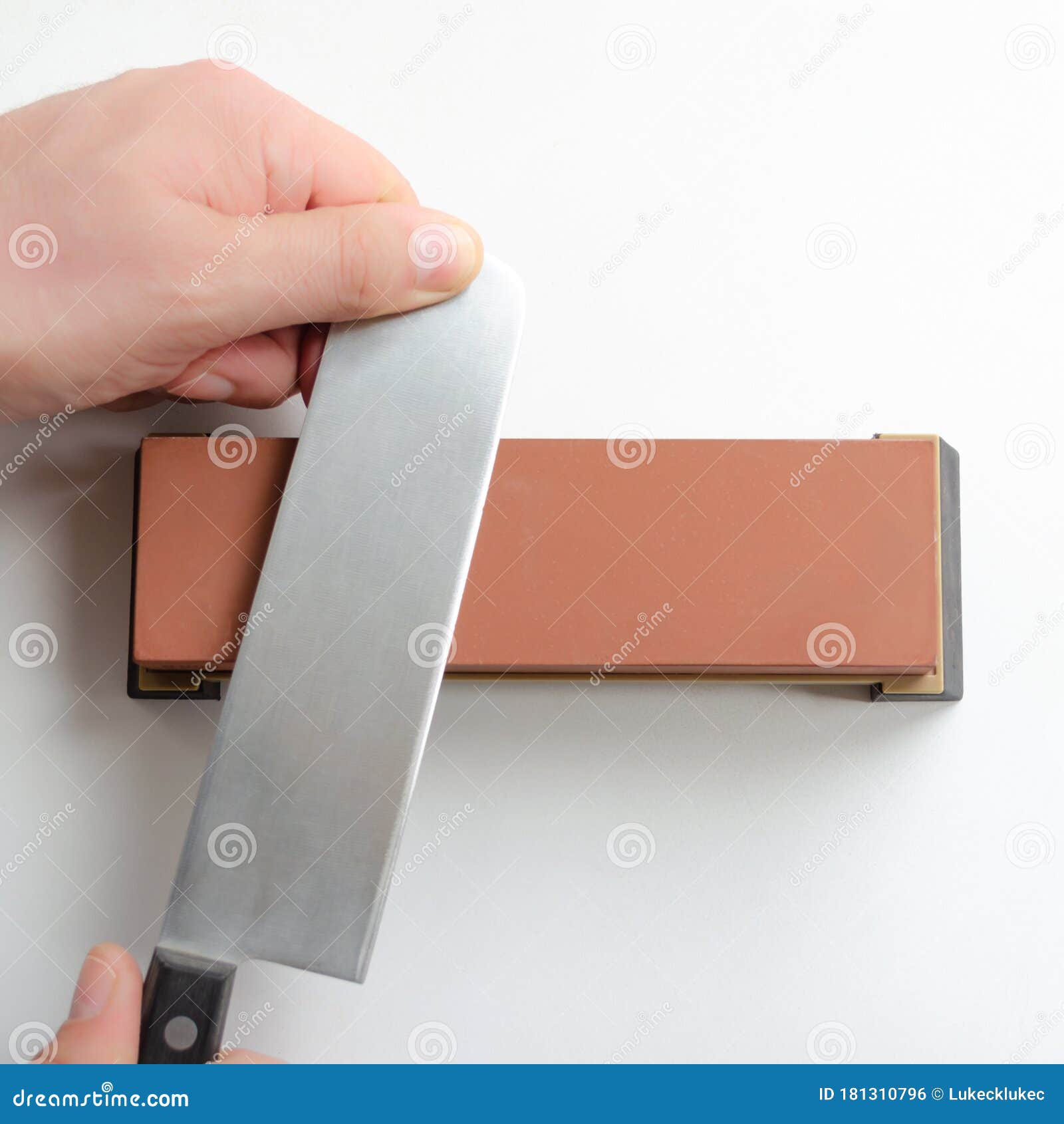 Man Sharpening a Japanese Nakiri Knife with Whetstone Sharpener Stock