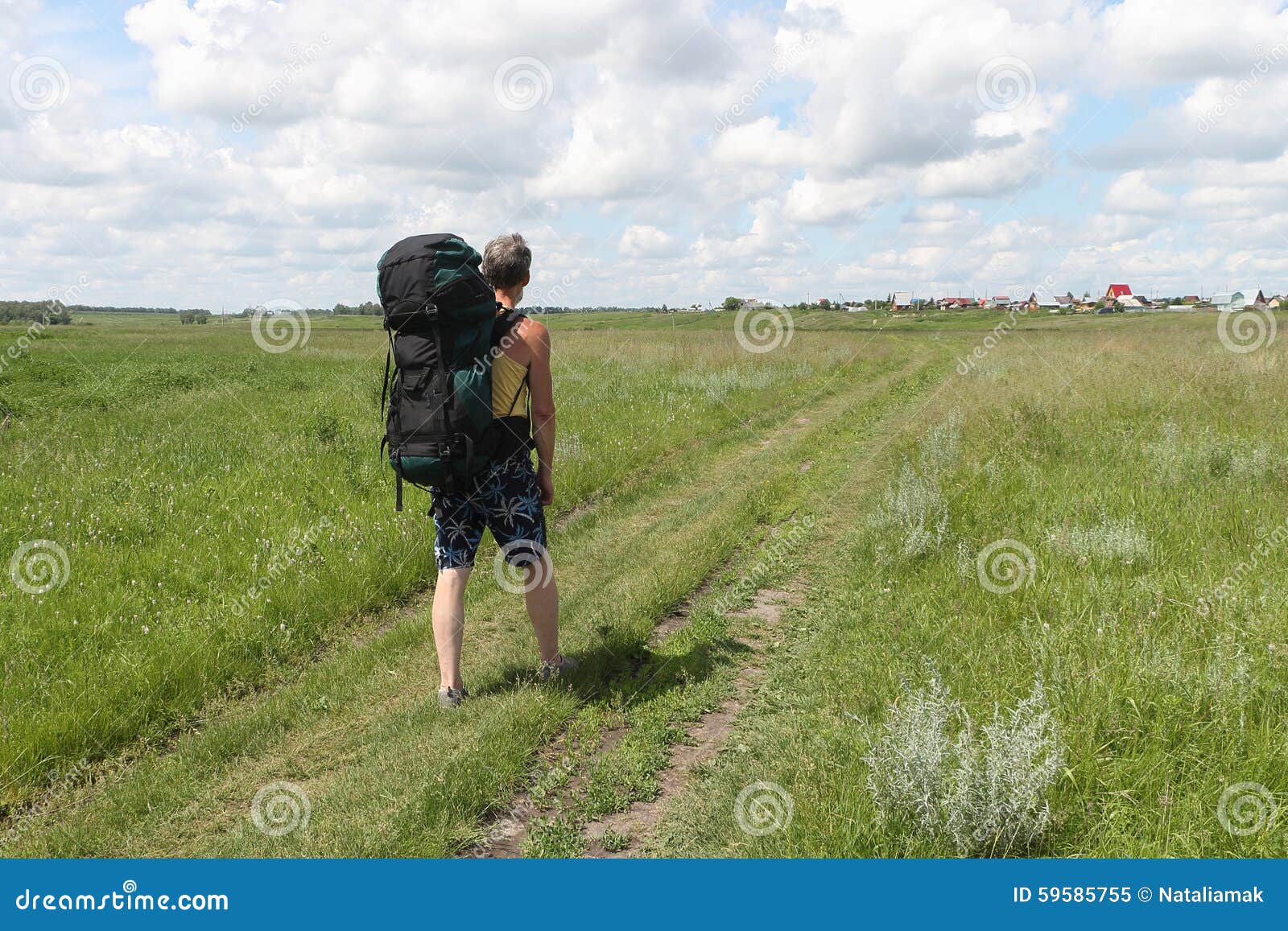 The Man in Shorts with a Backpack Going on the Rural Road Stock Image