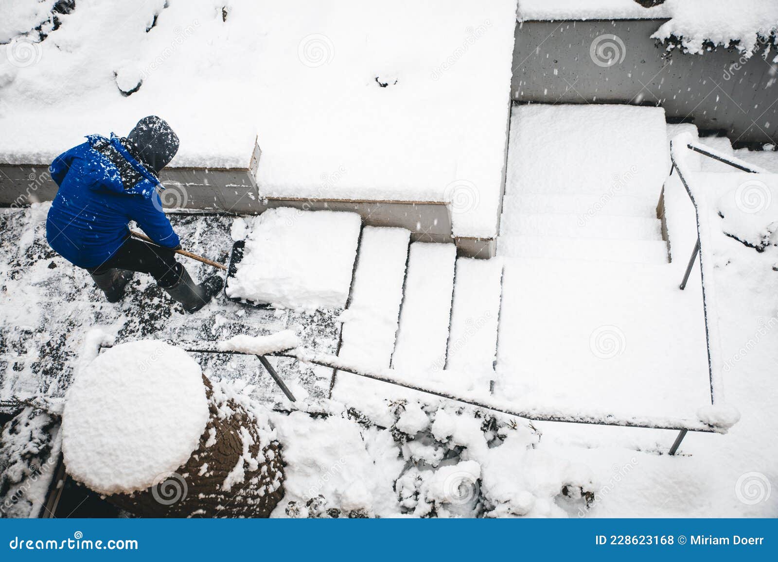 man shovelling staircases with a snow shovel or pusher, topview