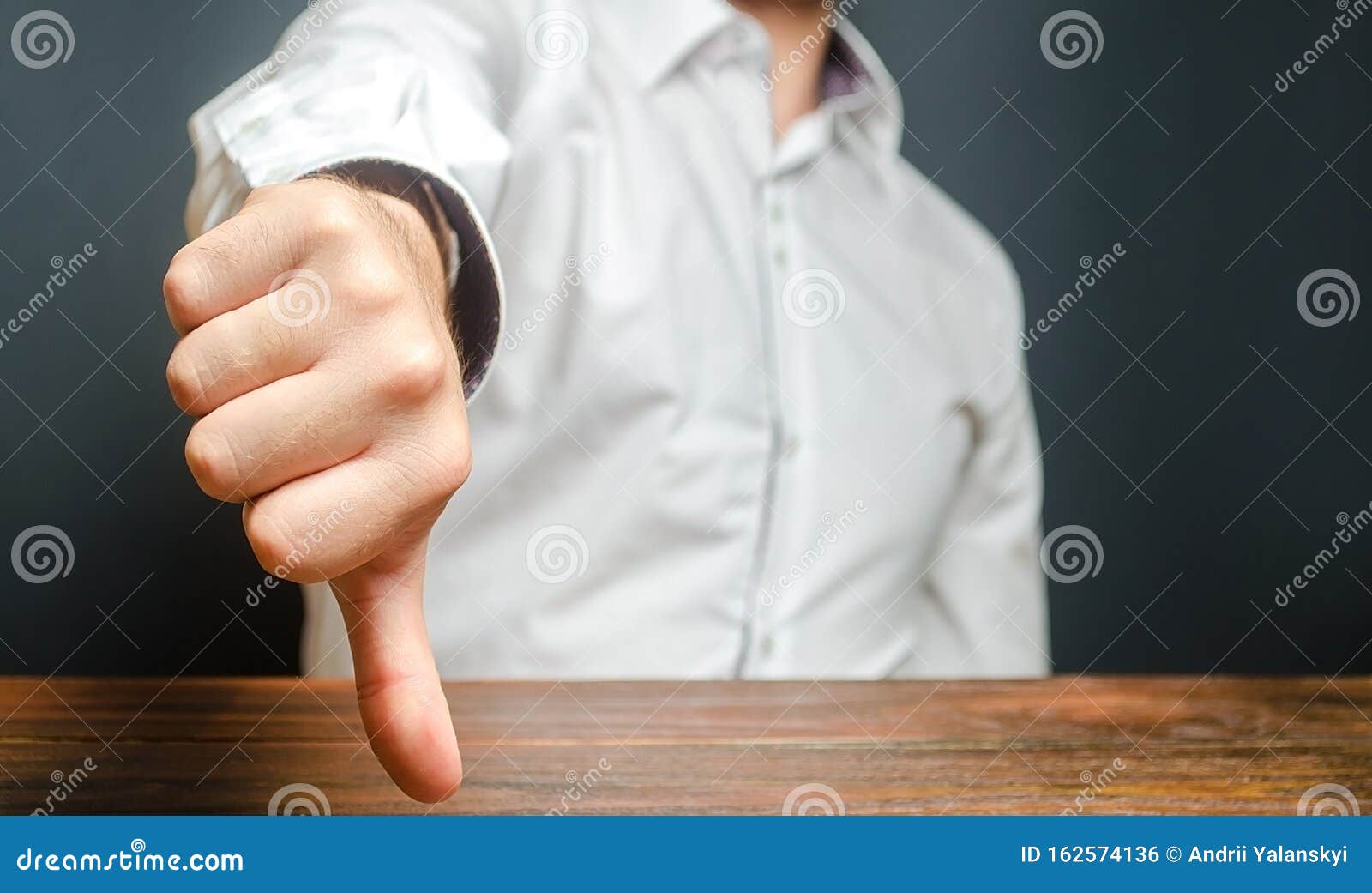 a man shows a thumb down. gesture of disapproval and rejection. bad assessment, harsh criticism, failure and defeat. refusal