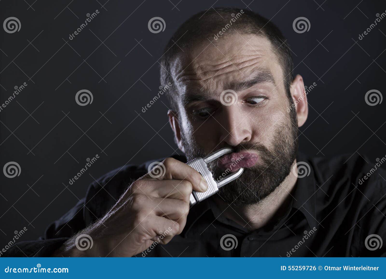 man silenced with locked mouth by a padlock.