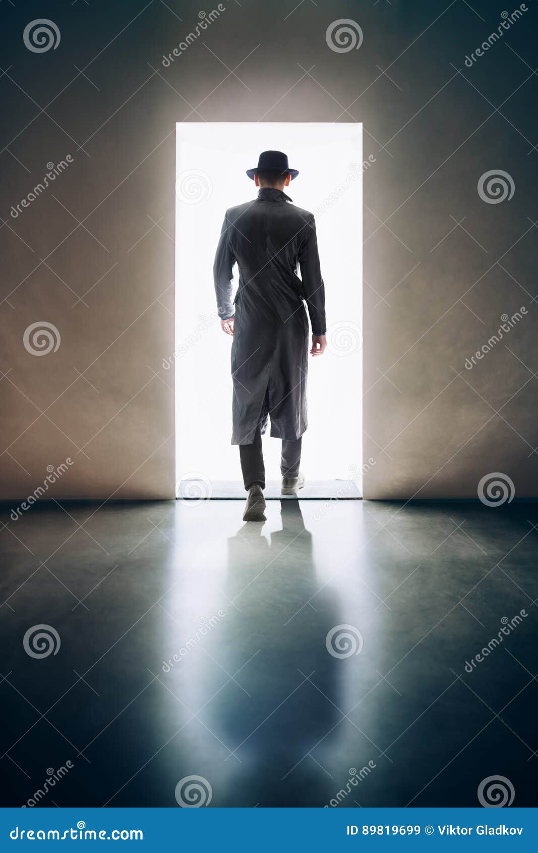 man silhouette walking away in the light of opening door in dark