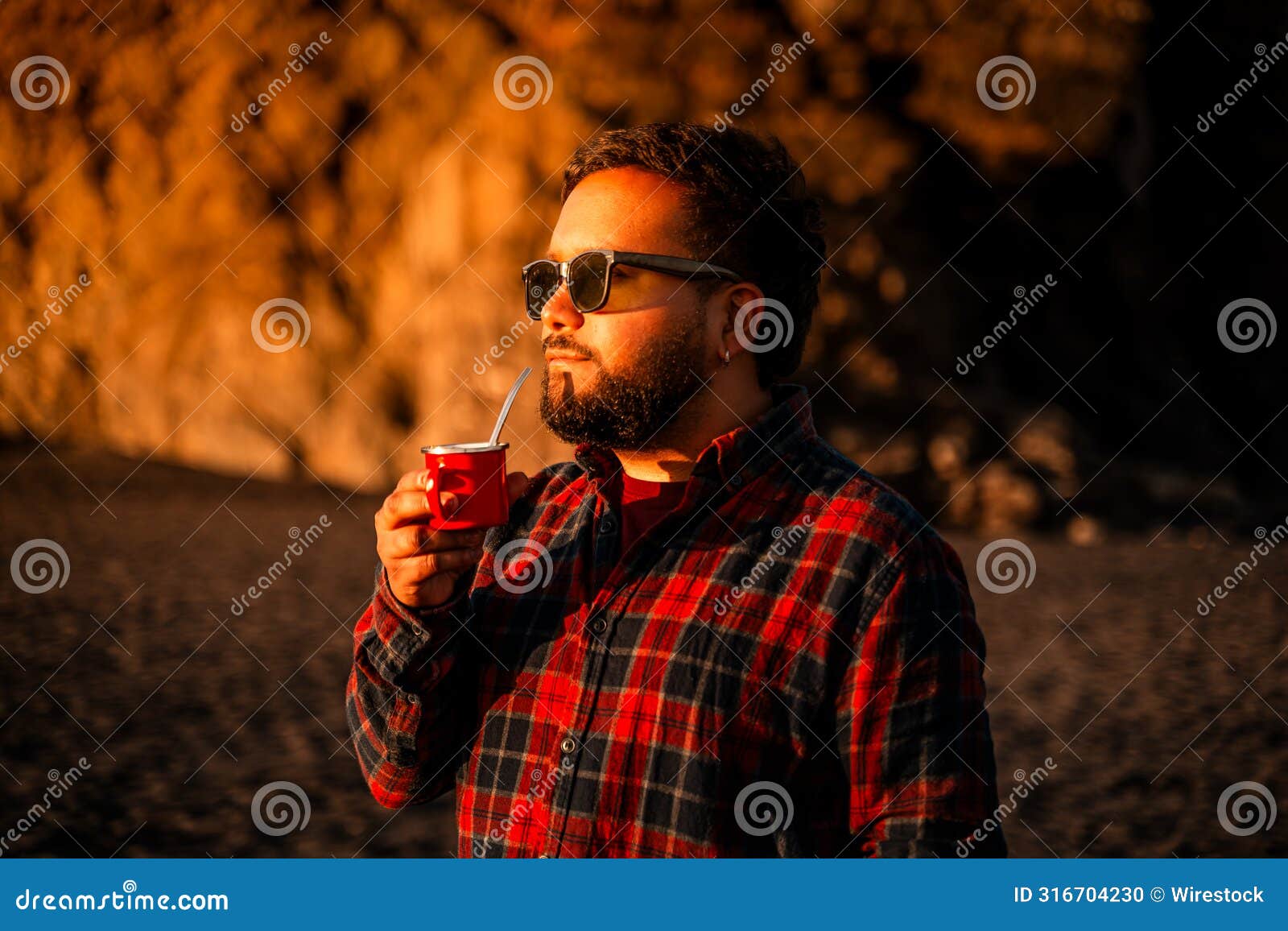 man sipping a drink under sunlight admiring the scene in cobquecura, nuble region, chile