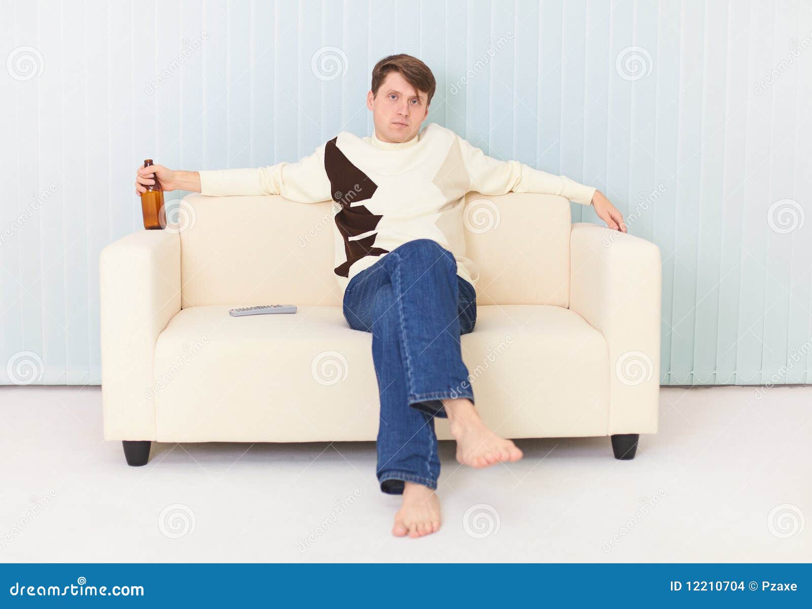 Man Sits on Sofa with Beer Bottle in a Hand Stock Photo Image of